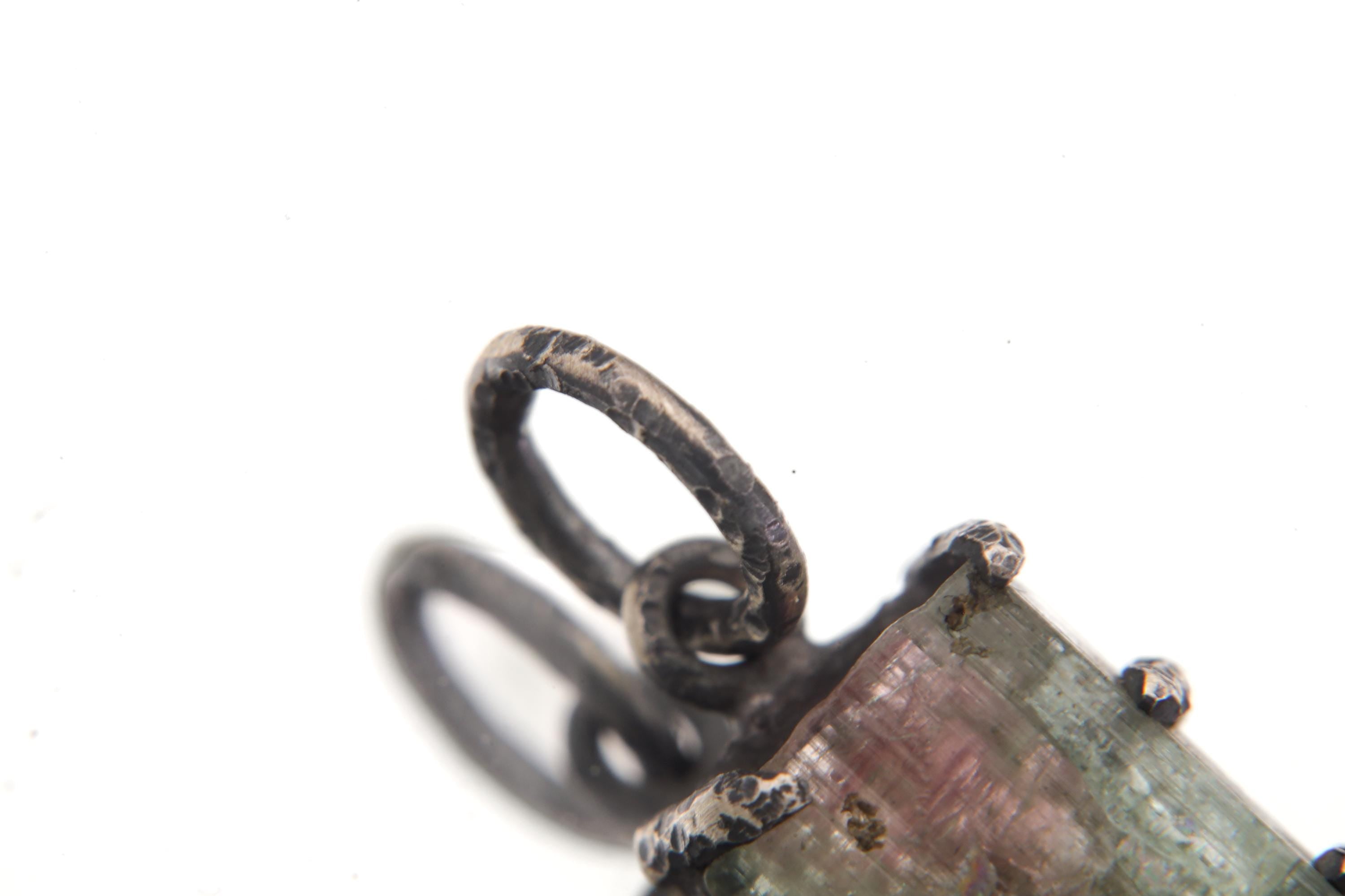 Macro of pendant showing silver prongs gripping the natural crystal edges.