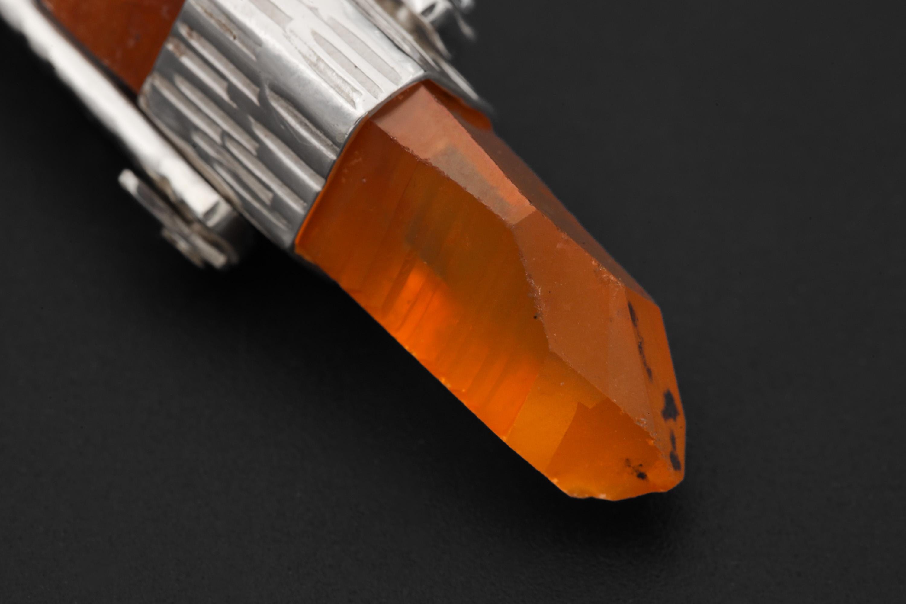 Close-up of Australian Lemurian Quartz point showing warm orange colour, natural crystal texture, and silver cap setting.