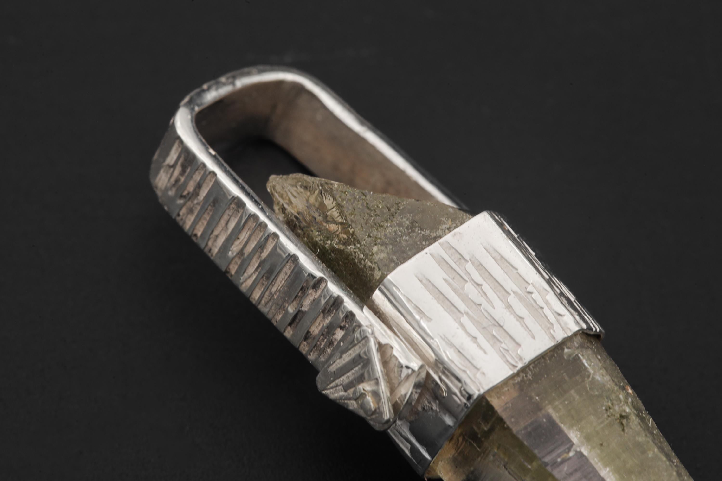 Close-up of Himalayan Lemurian Chlorite Rutile Quartz point showing internal mineral inclusions and clear crystal structure.