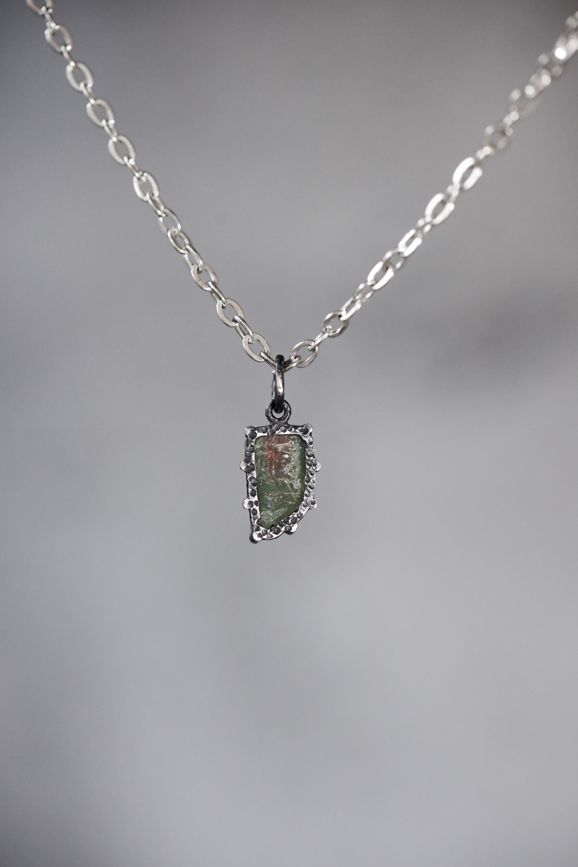 Close-up of Watermelon Tourmaline pendant showing pastel pink green zoning, natural rind edge, and oxidized silver claws.