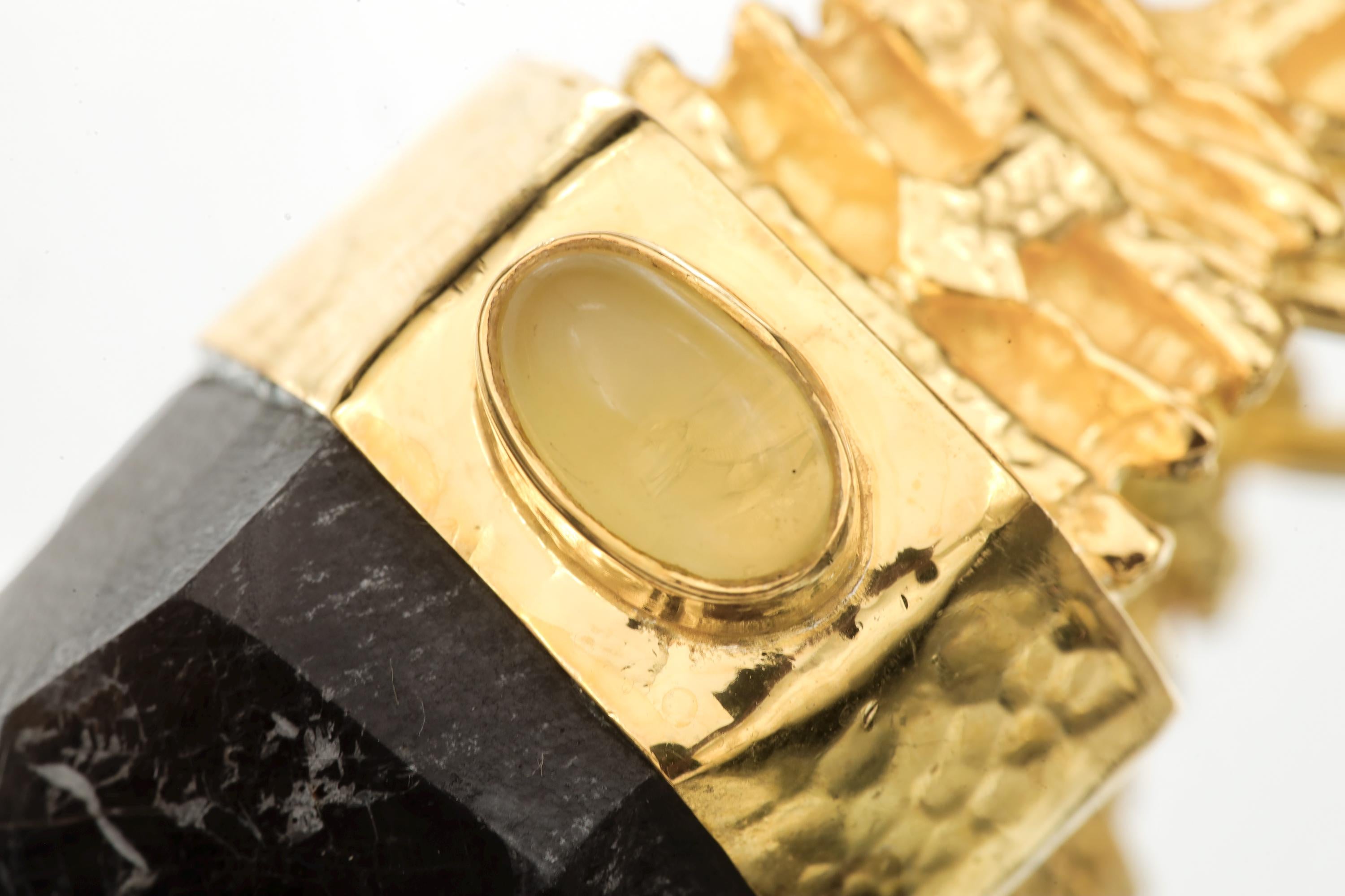 Close-up macro of opal bezel showing flashes of green, pink, and blue within the gold-plated frame.