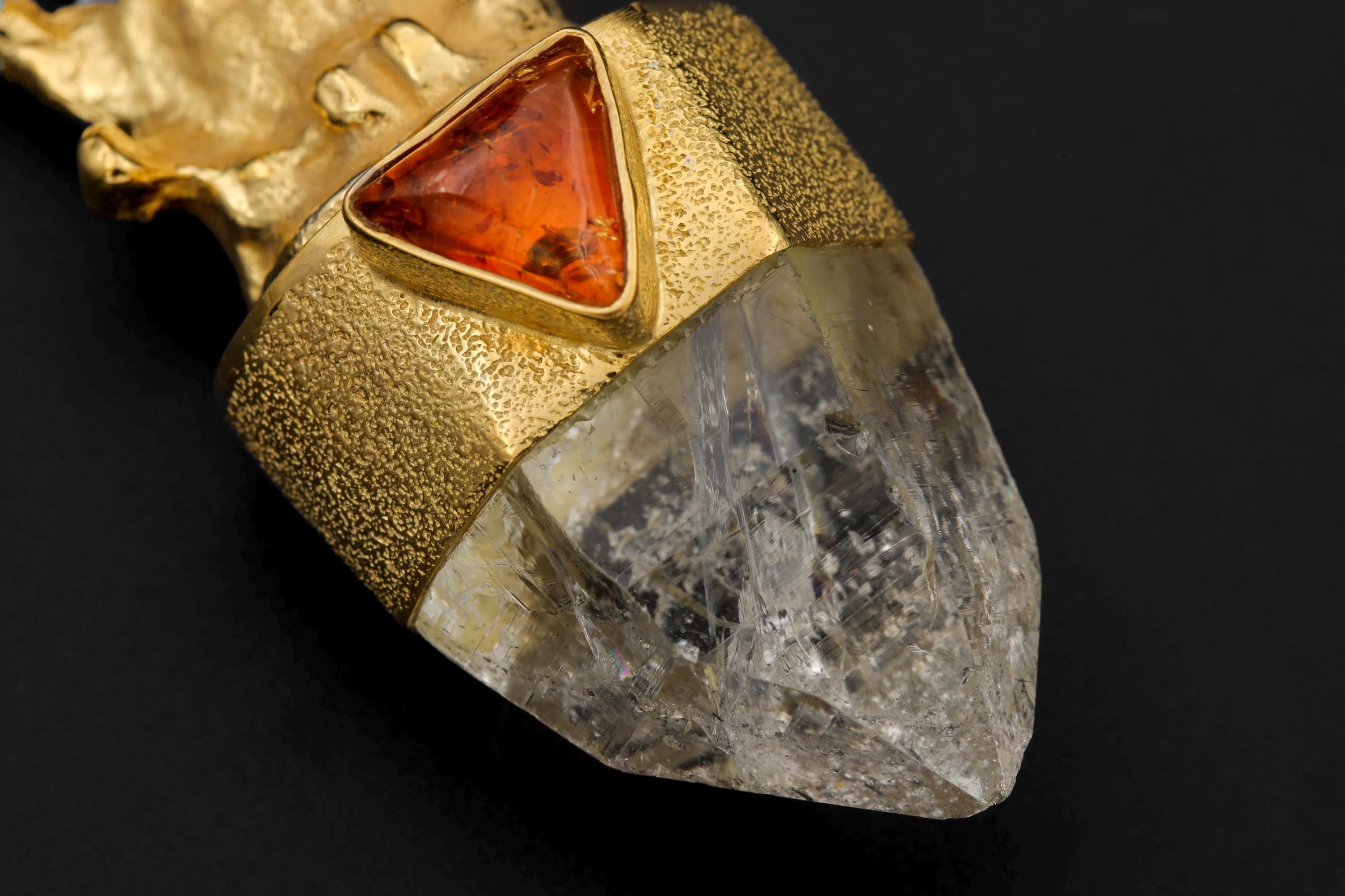 Close-up of amber bezel highlighting rich honey color, natural inclusions, and reflective gold-plated surface.