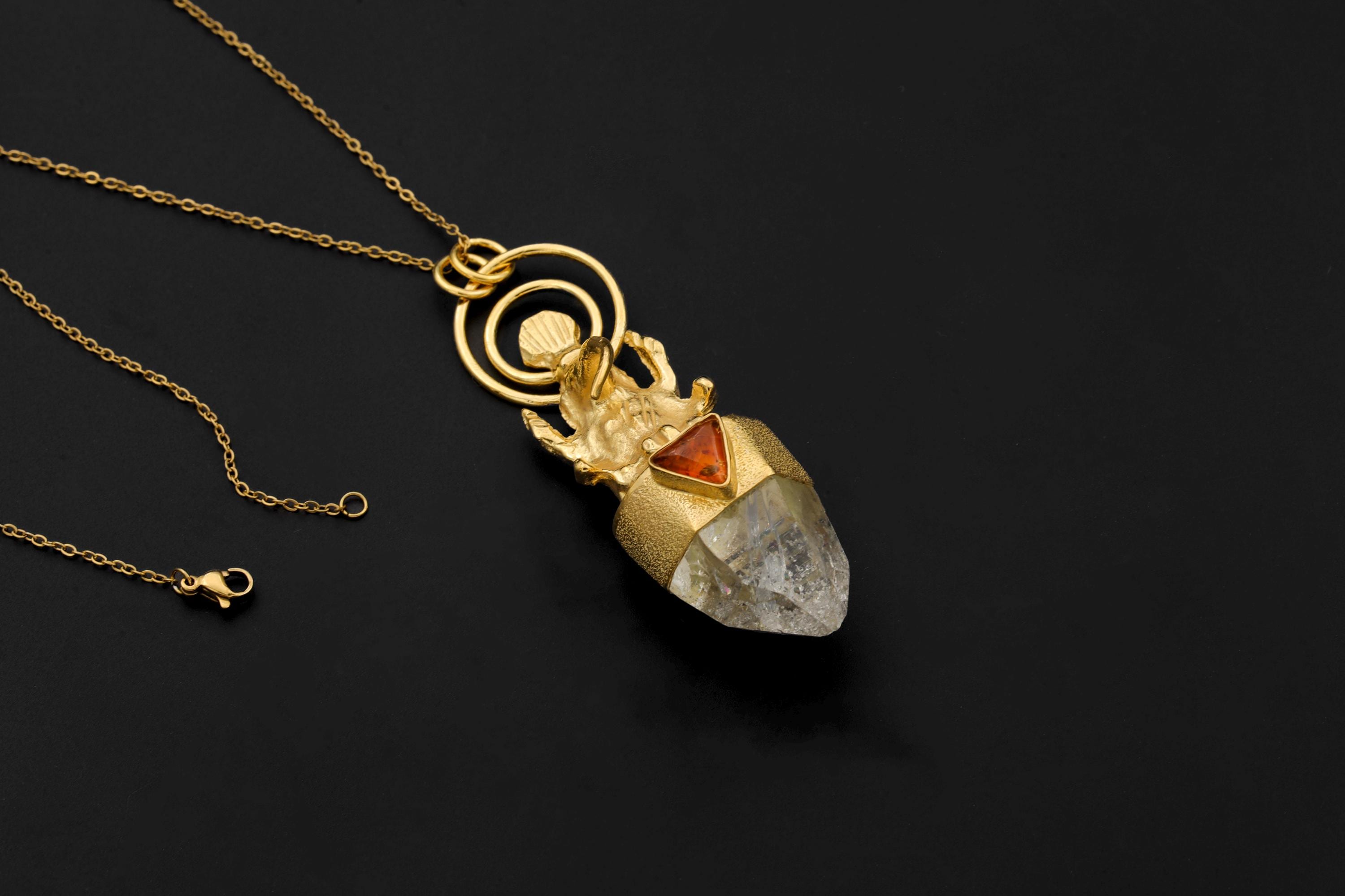 Pendant suspended with chain attached, highlighting wearable orientation and radiant metal finish.