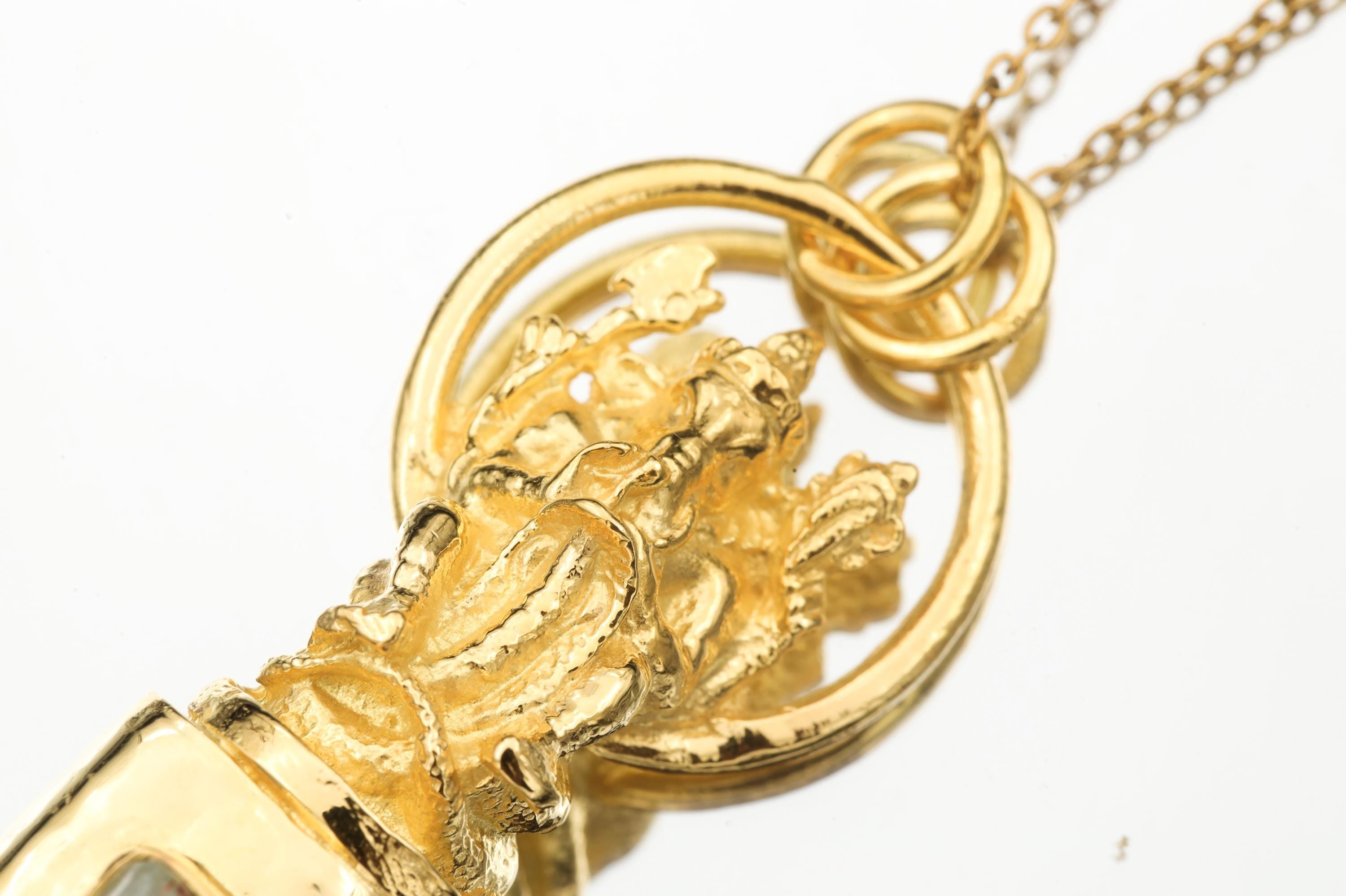 Close-up of cast brass figure detail and gold-plated setting above Aquamarine and Black Tourmaline stones.