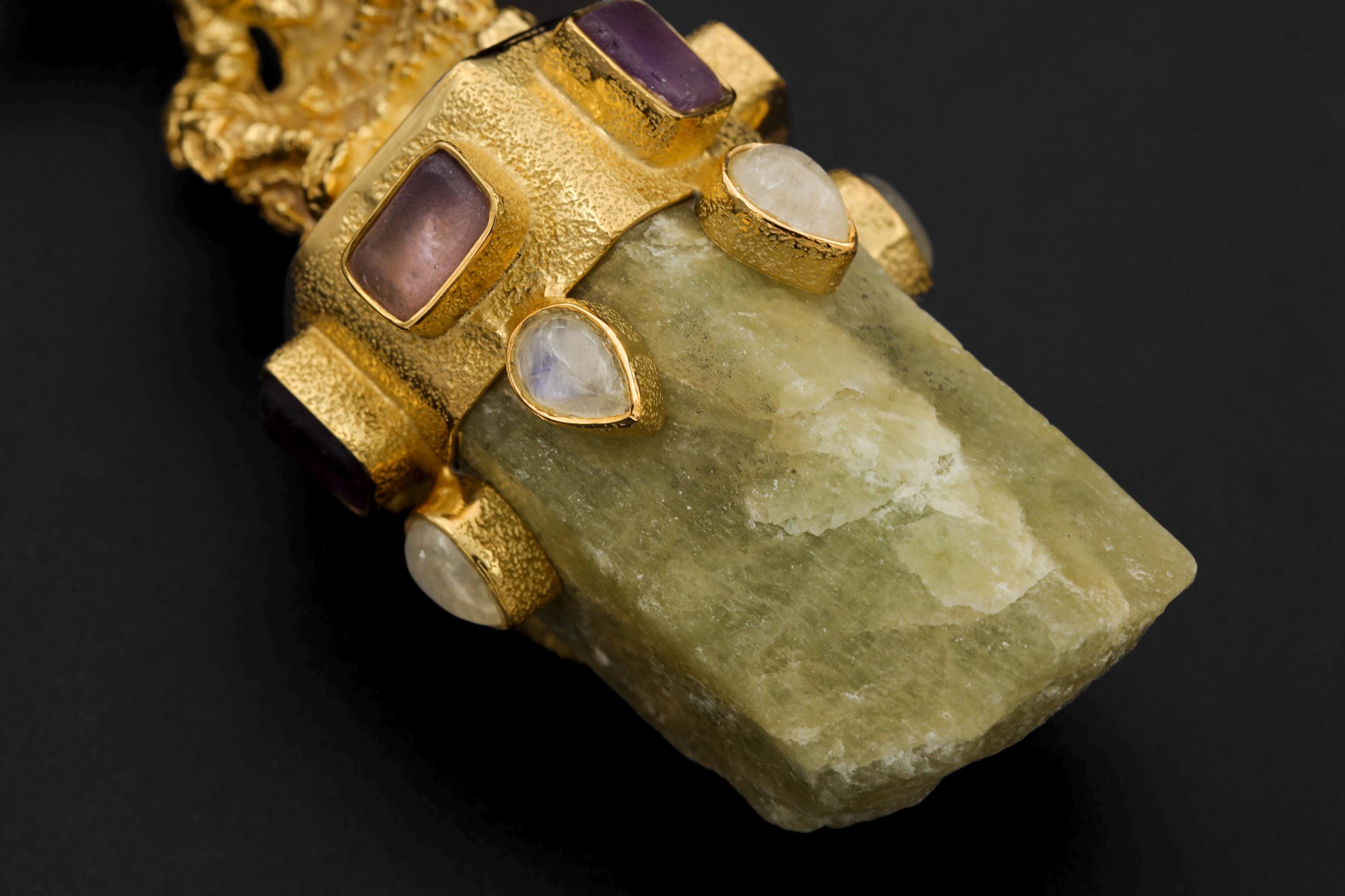 Close-up of pendant emphasizing texture and high-polish finish of gold plating with visible inclusions in Aquamarine.
