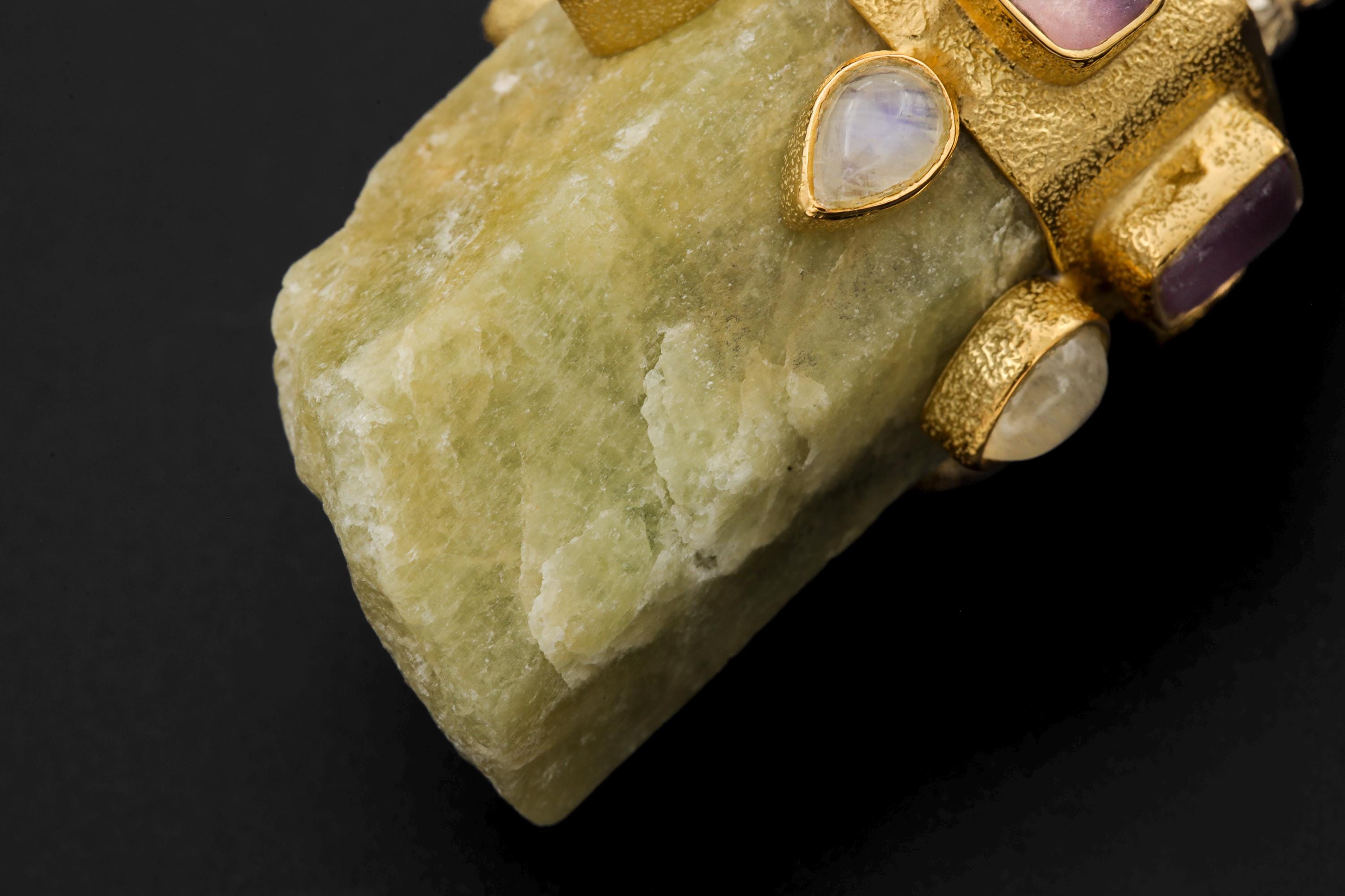 Pendant flat lay showing craftsmanship, polish variance, and balance between gemstones and metalwork.