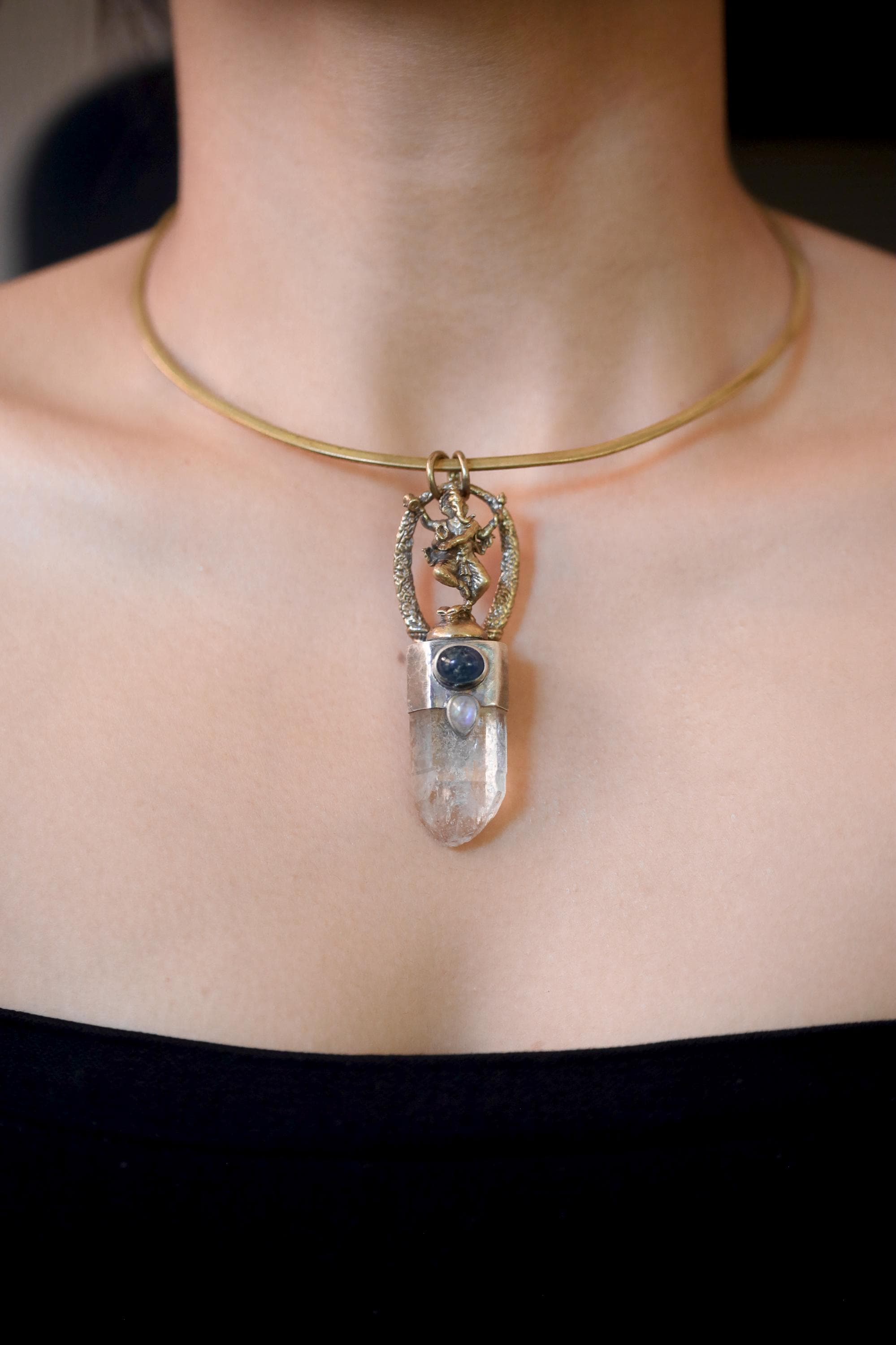 Pendant worn on model chest showing pendant length and natural light reflection of quartz and moonstone.