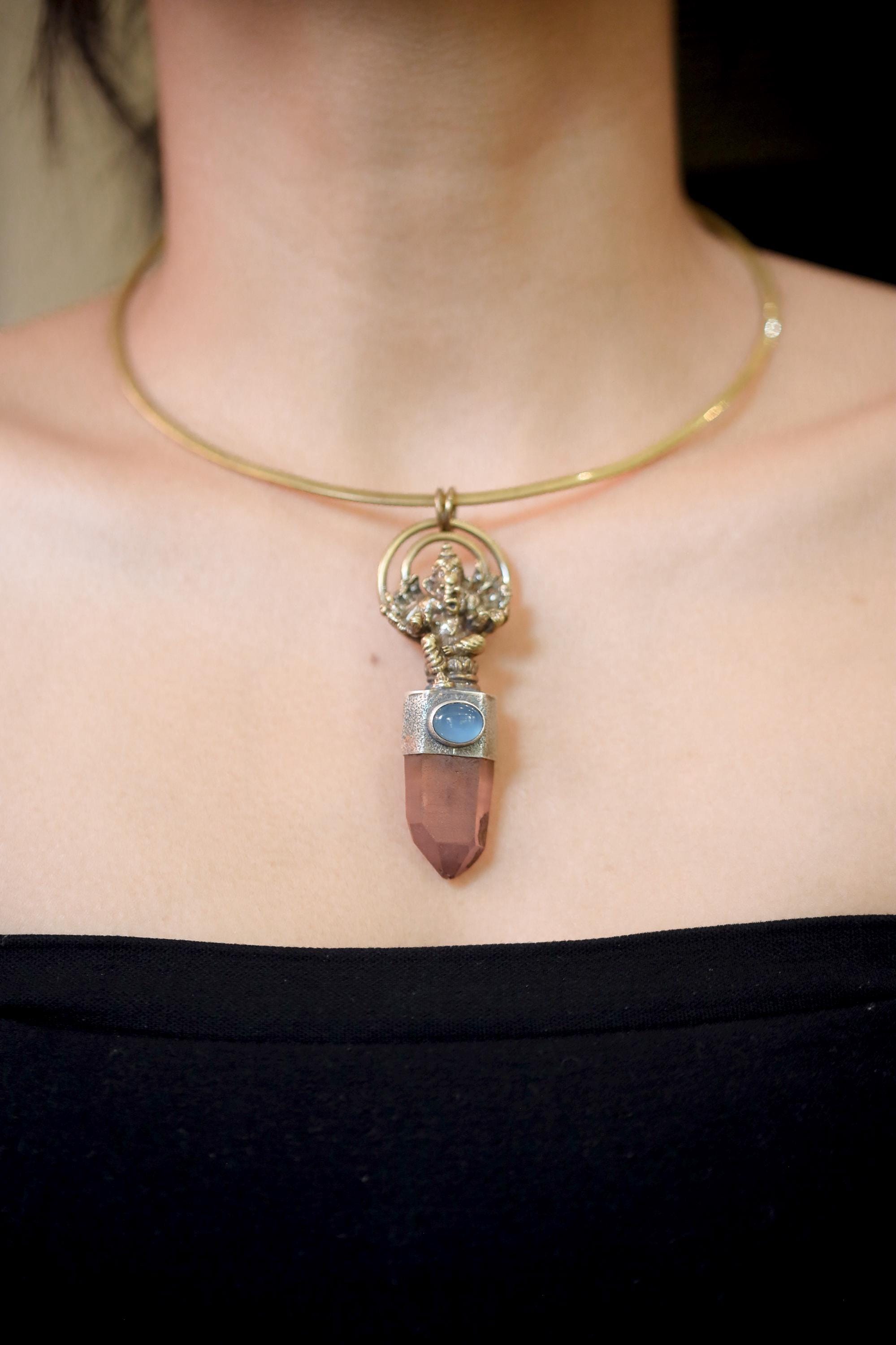 Pendant shown on model neckline to display proportion and brass Ganesha detailing in natural light.
