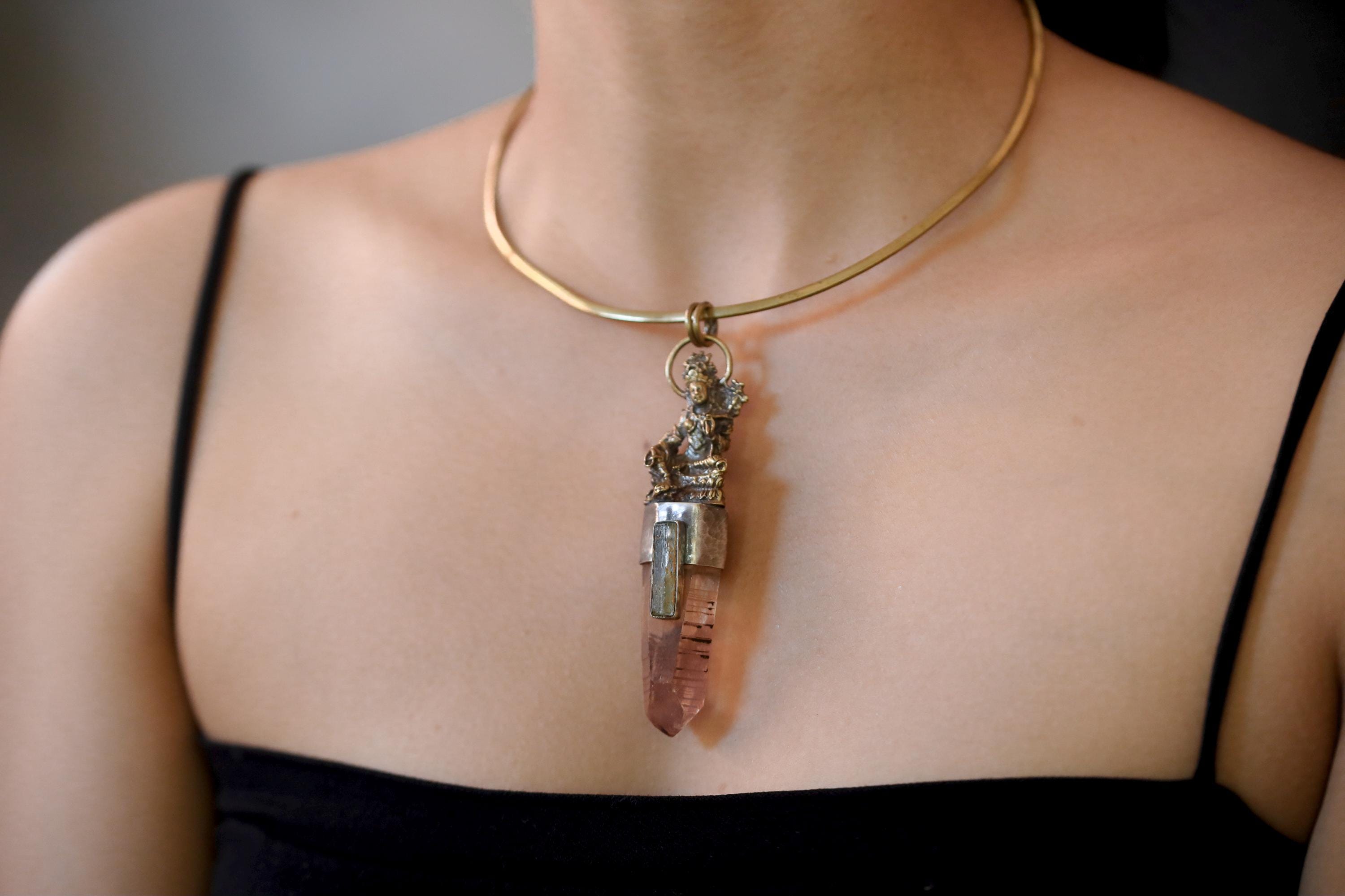 Pendant worn on model showing pendant length, balance between stones, and soft brass patina.
