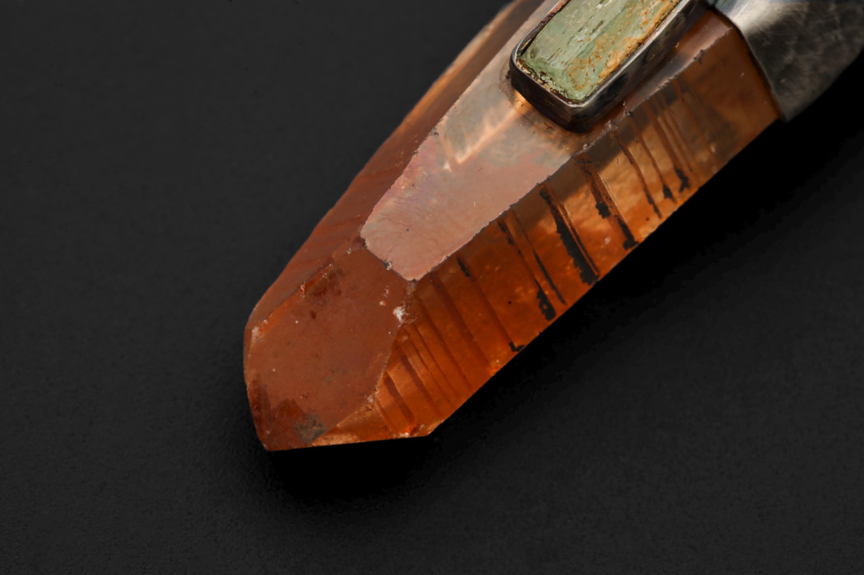 Macro detail photo focusing on aquamarine inclusion and silver oxidization pattern.