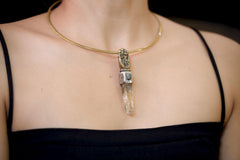 Pendant worn on model chest displaying pendant length, proportion to neckline, and warm golden tone of brass against silver bezel contrast.