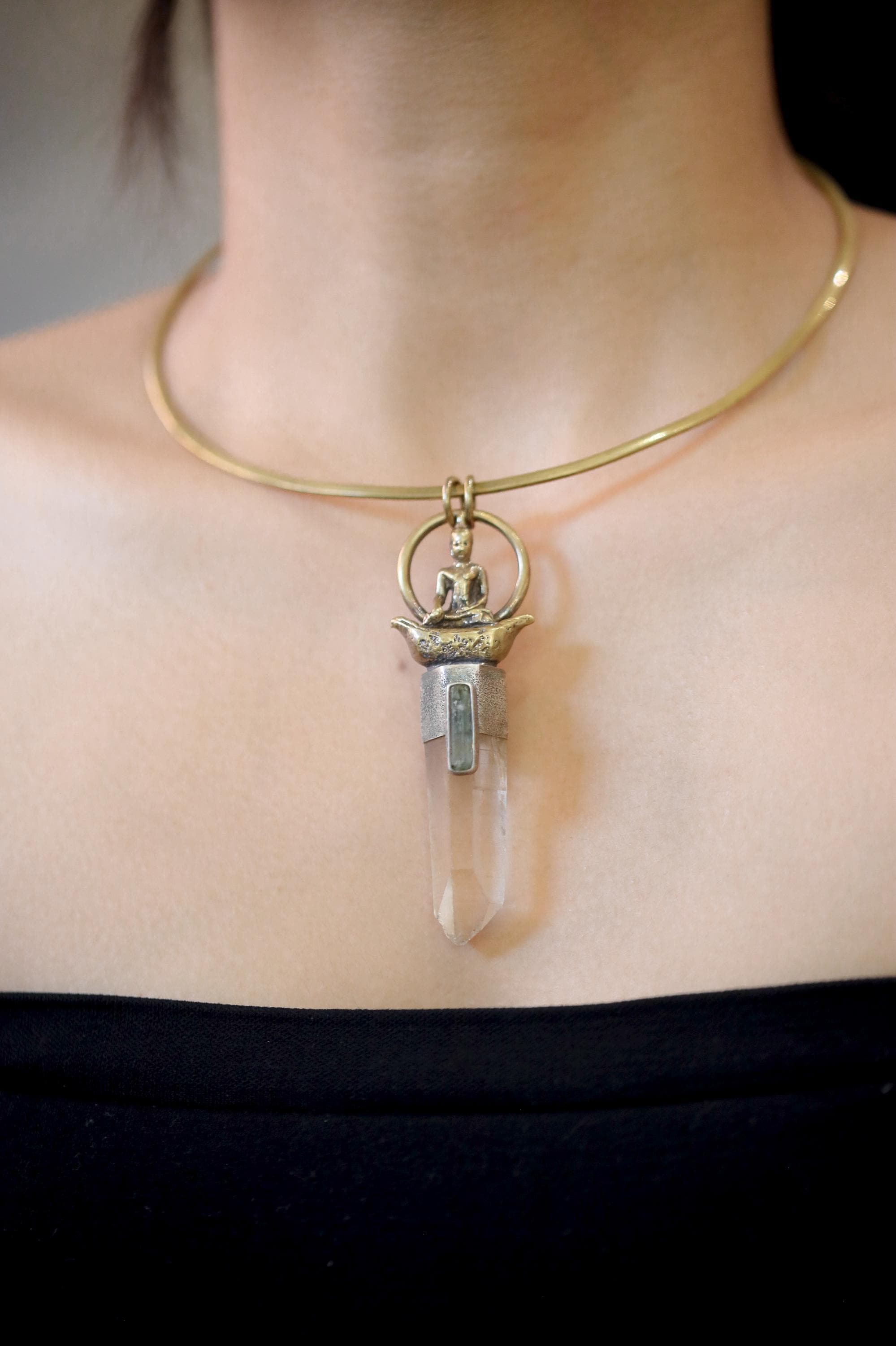 Pendant suspended against gradient grey background showing clarity, refraction, and balanced proportion of metals.