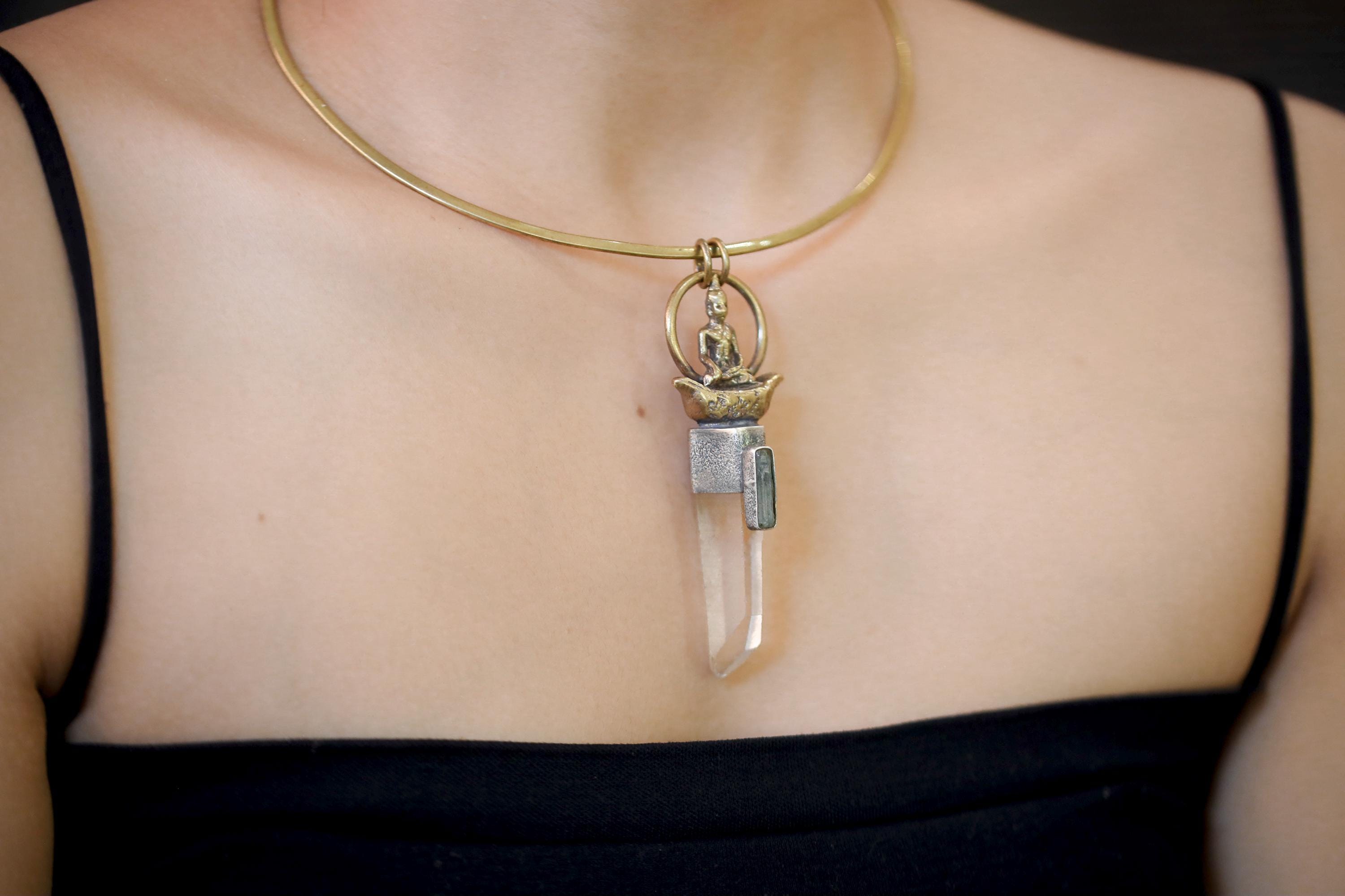 Model shot showing pendant in natural wear position with visible reflection across quartz facet.