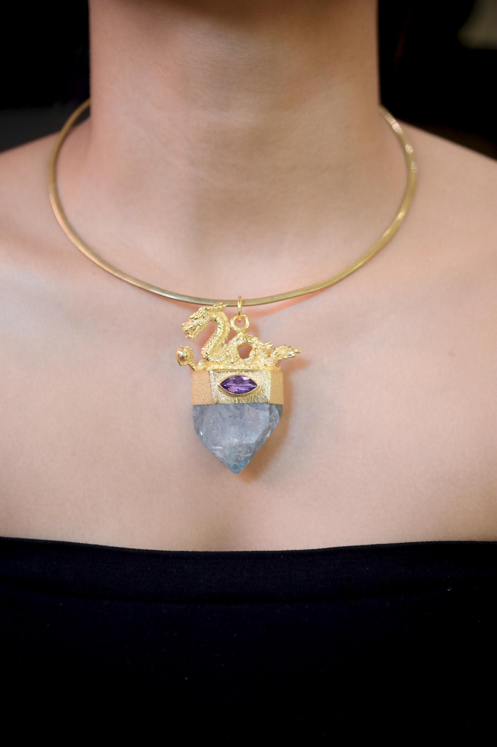 Pendant worn on model chest highlighting pendant length, gemstone alignment, and radiant gold sheen under soft light.