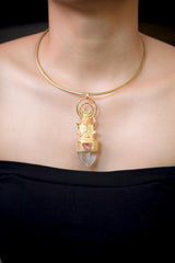 Pendant worn on model chest showing full pendant length, balanced design, and warm golden hue against skin tone.