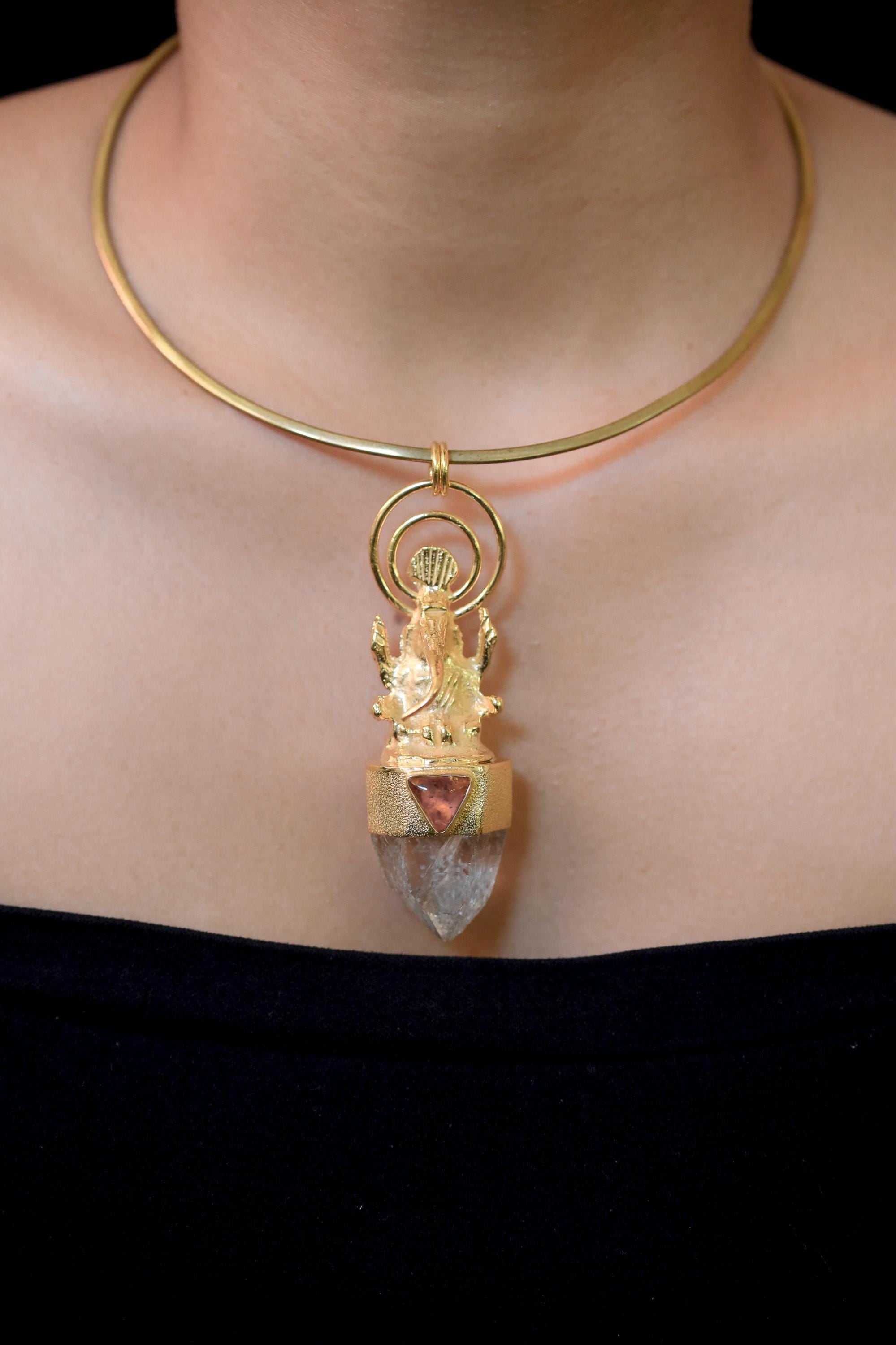 Pendant on model neckline under soft light showing refined craftsmanship and proportion.