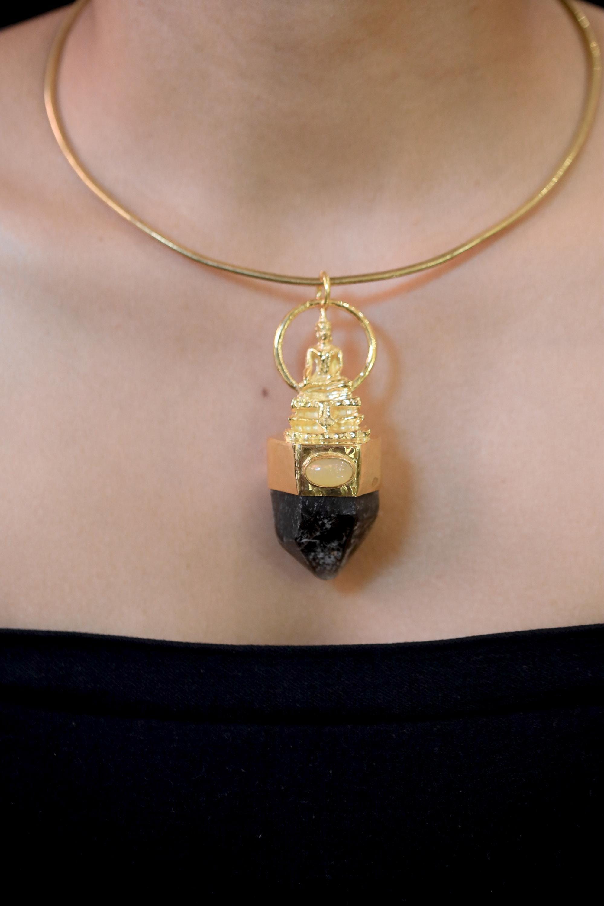 Pendant on model neckline in natural light revealing contrast between opal glow and smoky quartz grounding tone.