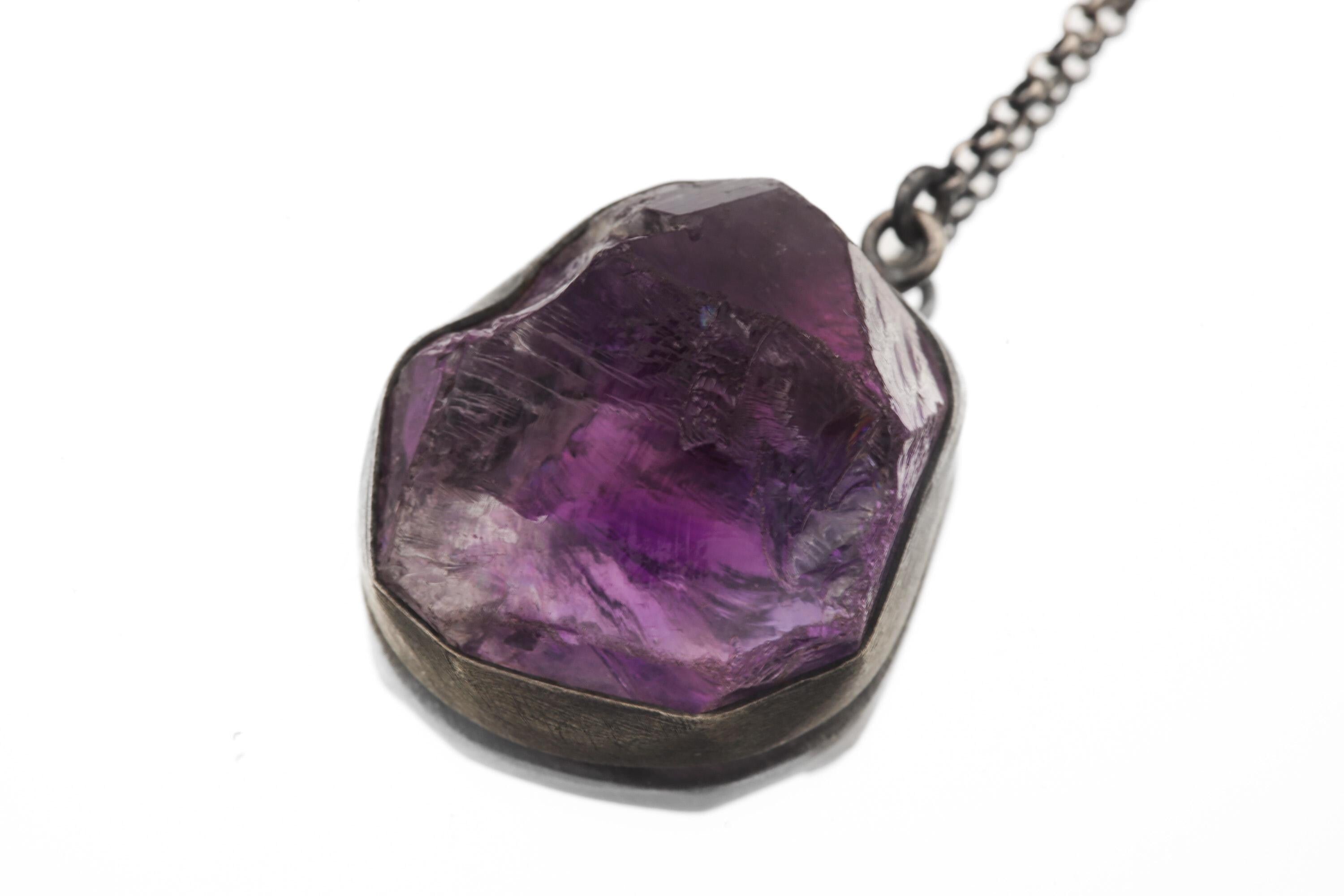 Close view of raw Amethyst pendant showing violet crystal texture in oxidized sterling silver setting.