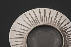 Close-up of Sun Motif pendant showing scratch-textured sterling silver rays and central magnifying glass lens.