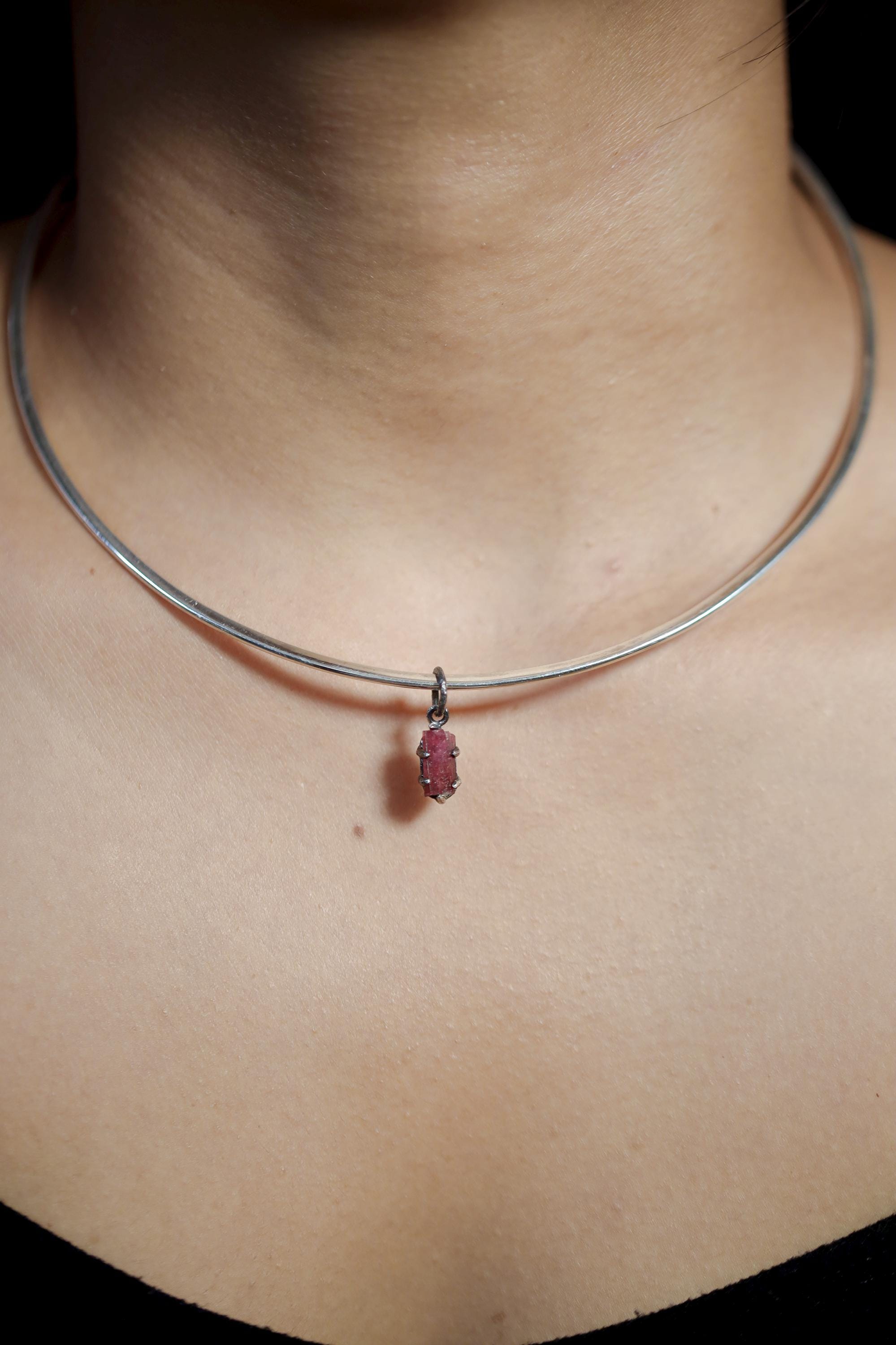 Pink Tourmaline Rubellite wand pendant shown close up with deep rose crystal and hammered silver claws.