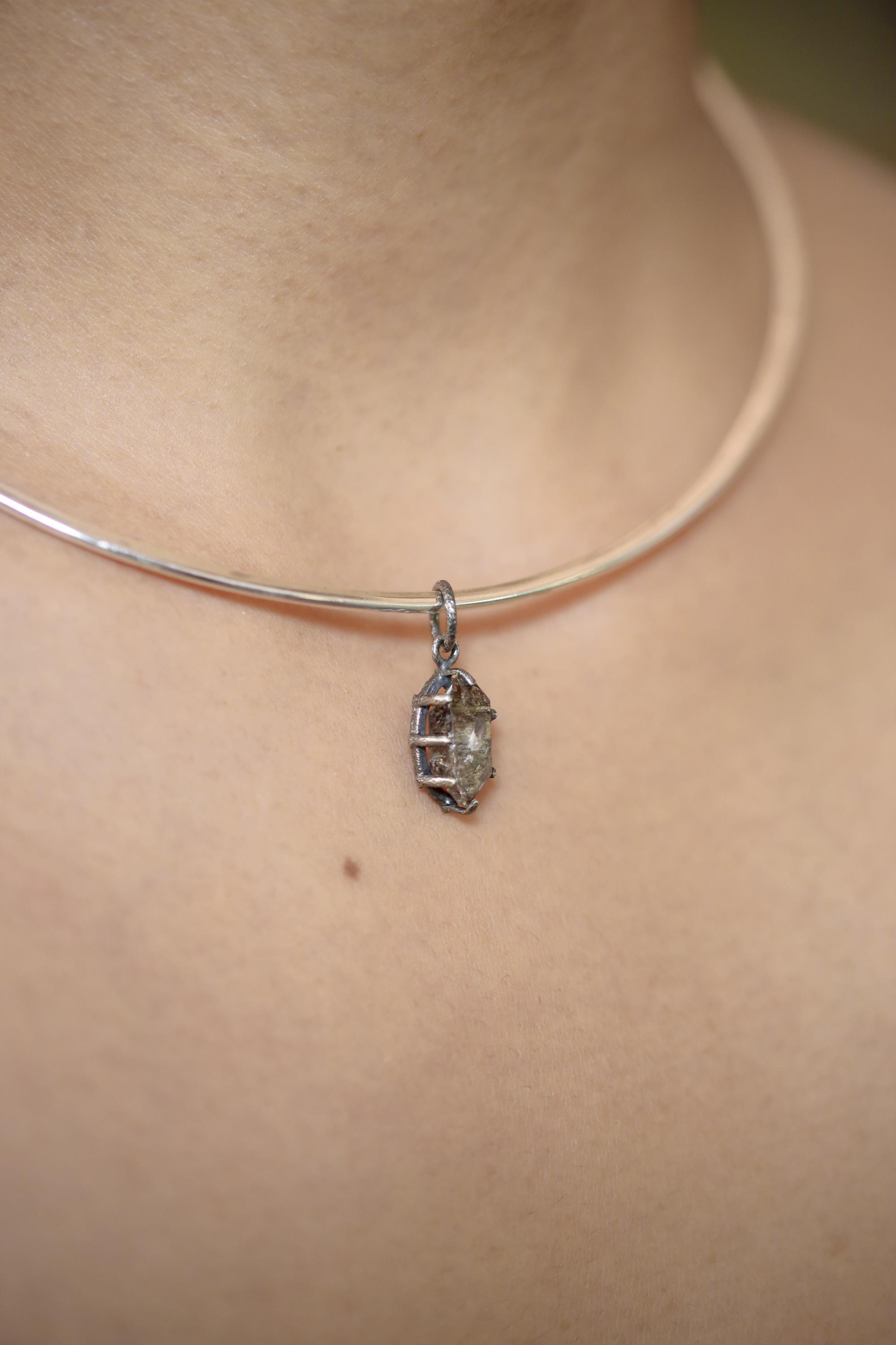 Tibetan Tabular Petroleum Inclusion Quartz pendant on white background showing raw crystal surface and handmade silver claws.