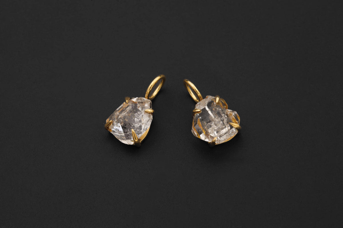 Herkimer Diamond Quartz pendant pair shown on black background with gold-plated sterling silver claws.