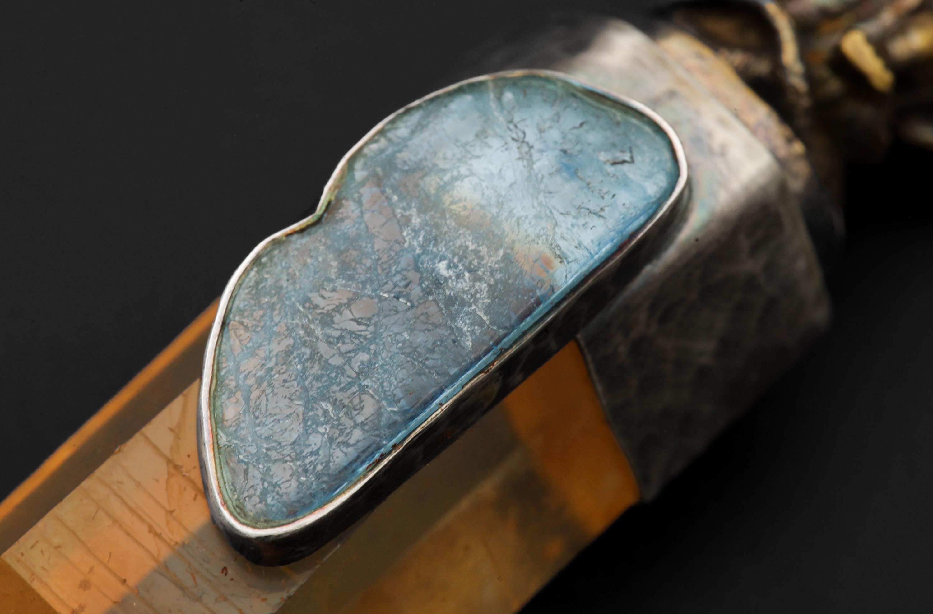 Close view of Lemurian Quartz pendant showing Aquamarine bezel and golden crystal point.