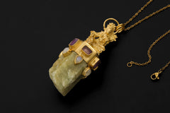 Praying Sarasvati talisman shown on dark background with Australian Aquamarine, Amethyst squares, Blue Moonstone, and gold-plated finish.