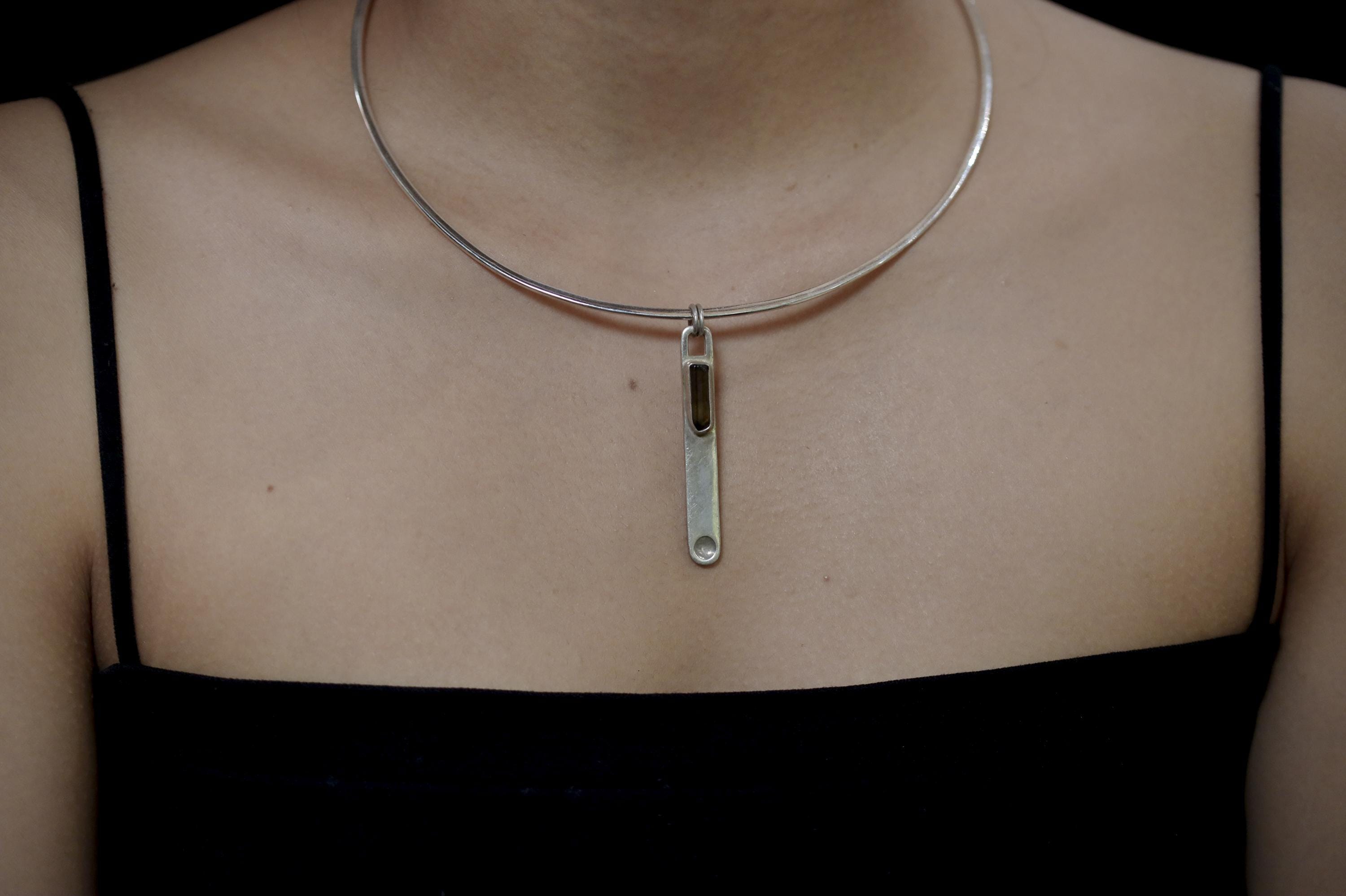 Dravite Tourmaline sterling silver wand pendant worn on a model as a minimal grounding crystal necklace.