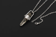 Himalayan Lemurian Chlorite Rutile Quartz pendant shown on black background with chain, high-polish sterling silver, and crystal point.