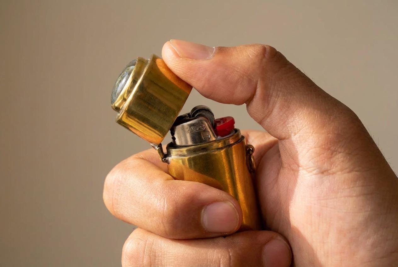 Brass lighter box pendant shown open in hand with lighter inside, side rings, and Labradorite-topped lid.