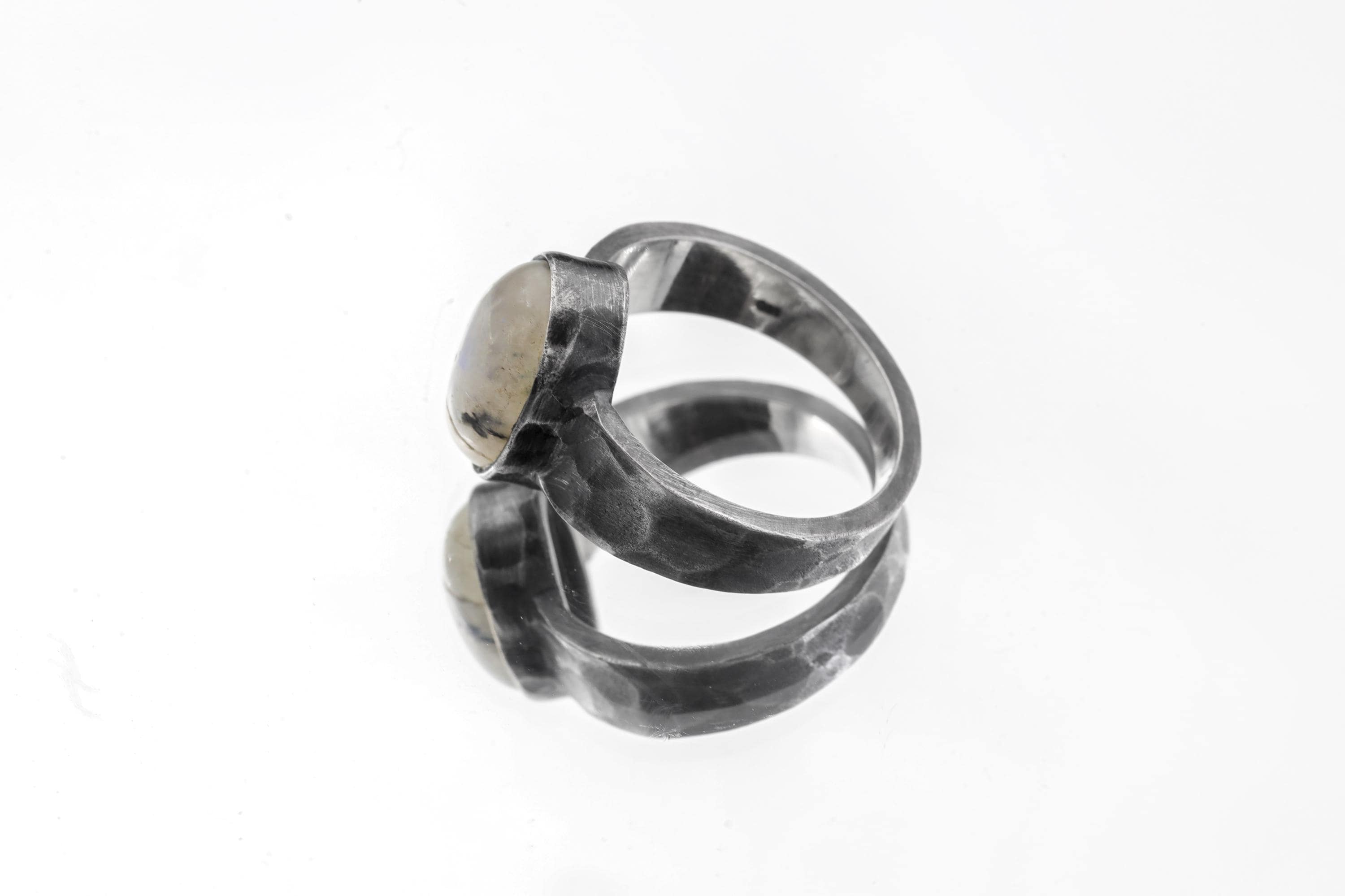 Side view of Blue Moonstone men’s ring showing wide hammered oxidized sterling silver band and raised bezel setting.