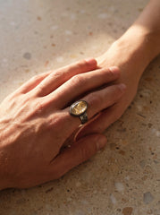 Gold Rutilated Clear Quartz men’s ring in oxidized 925 sterling silver shown worn on the hand with hammered silver band.