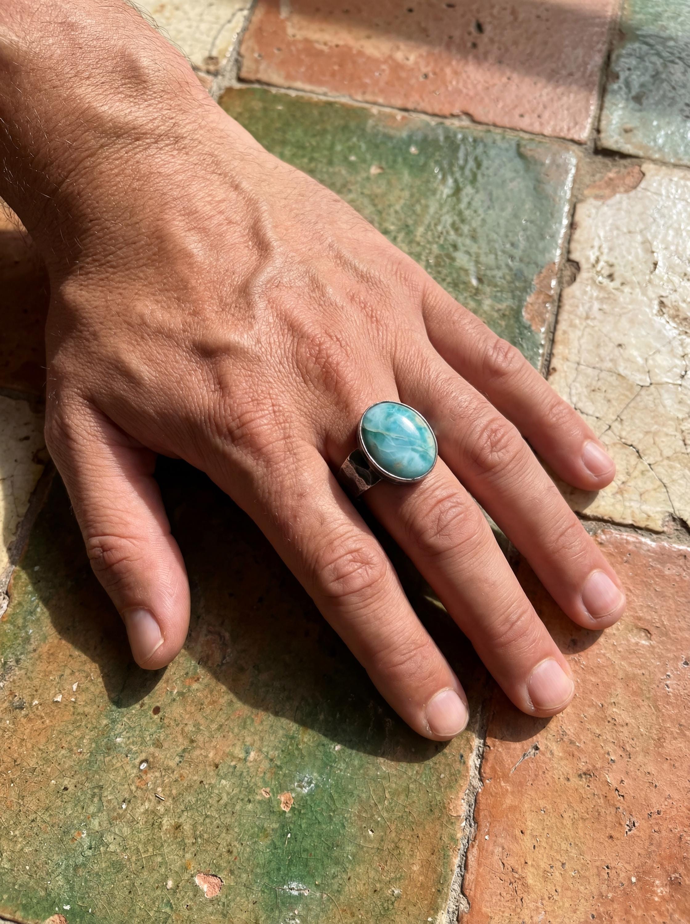 AAA Larimar oval cabochon ring shown on the hand, with sky-blue stone and rugged oxidized sterling silver.