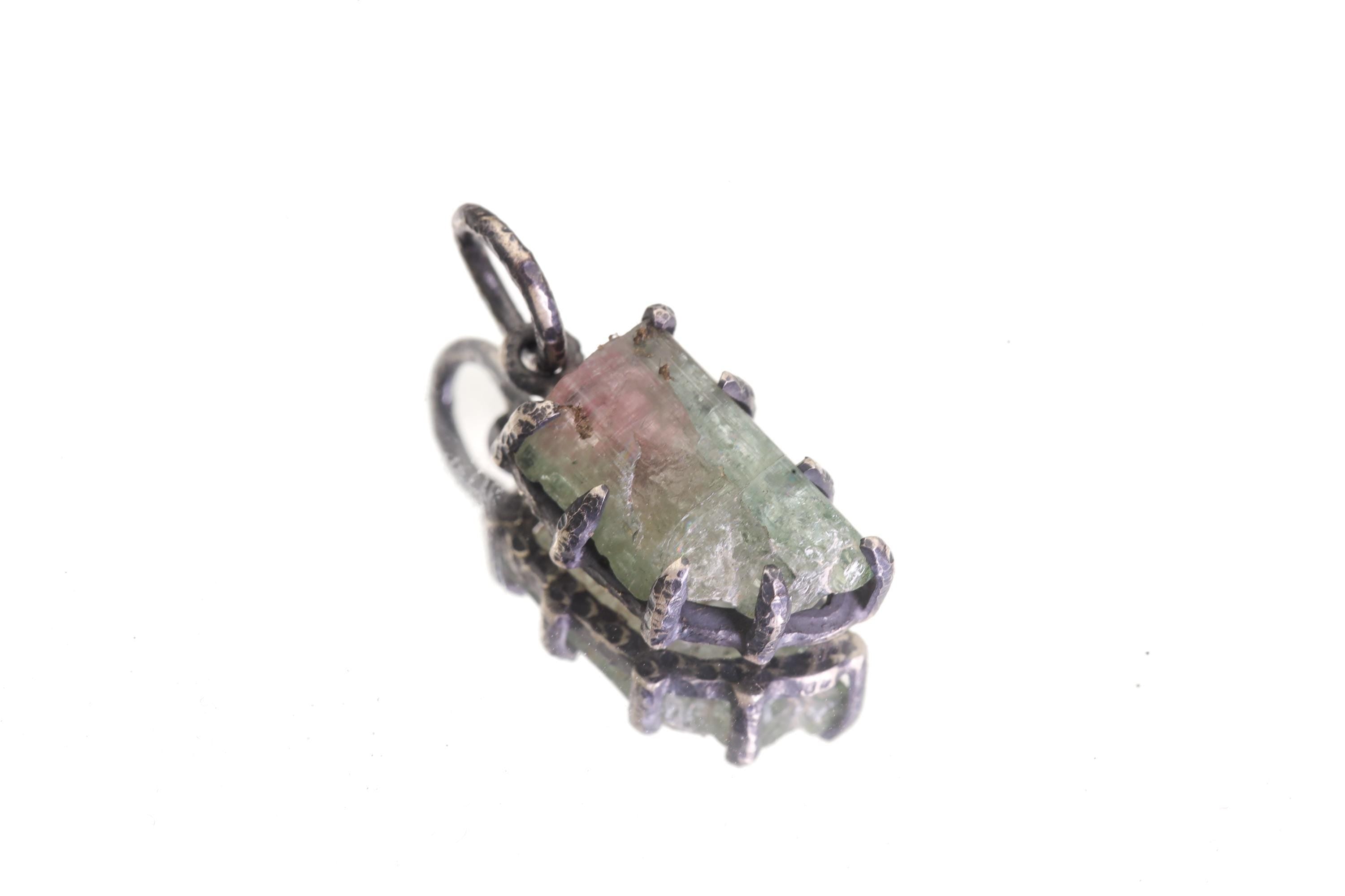 Overhead view of pendant showing oxidized silver bail and claw details.