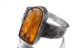Close-up of raw Orange Kyanite specimen ring showing deep orange crystal structure and oxidized silver bezel.