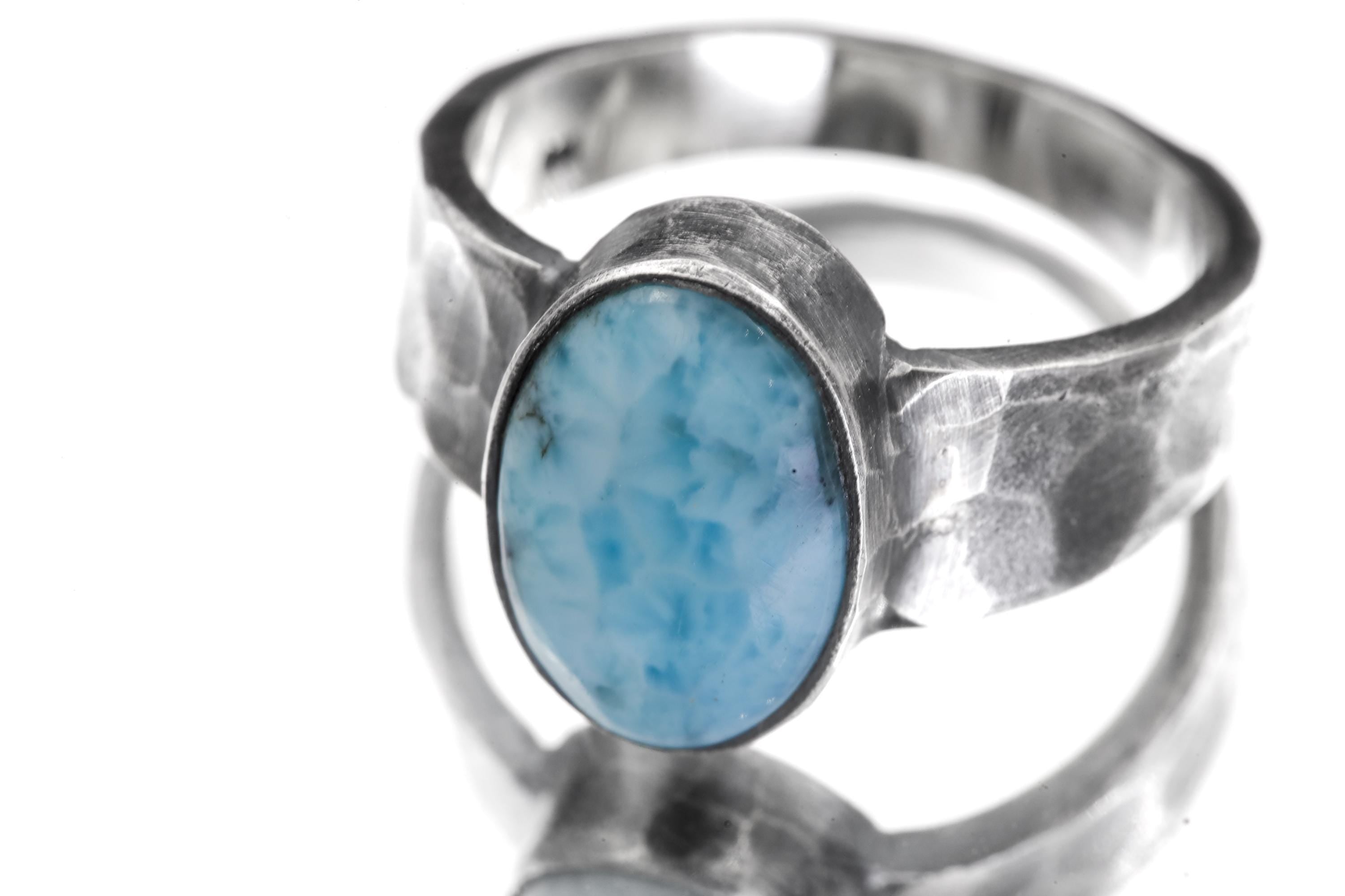 Close view of Larimar sterling silver ring showing sky blue cabochon and hammered oxidized band.