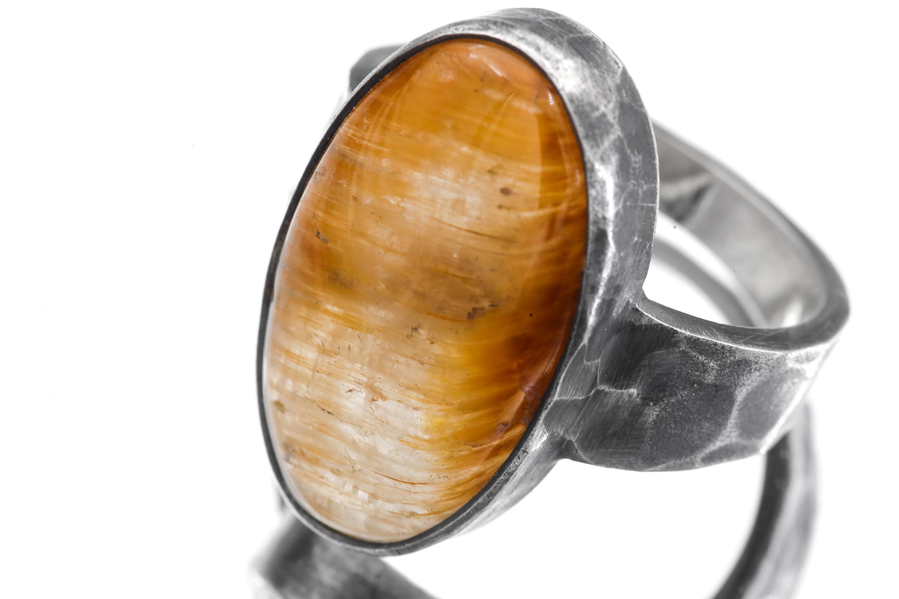 Close view of oval Gold Rutilated Quartz ring showing golden needle inclusions in clear crystal.