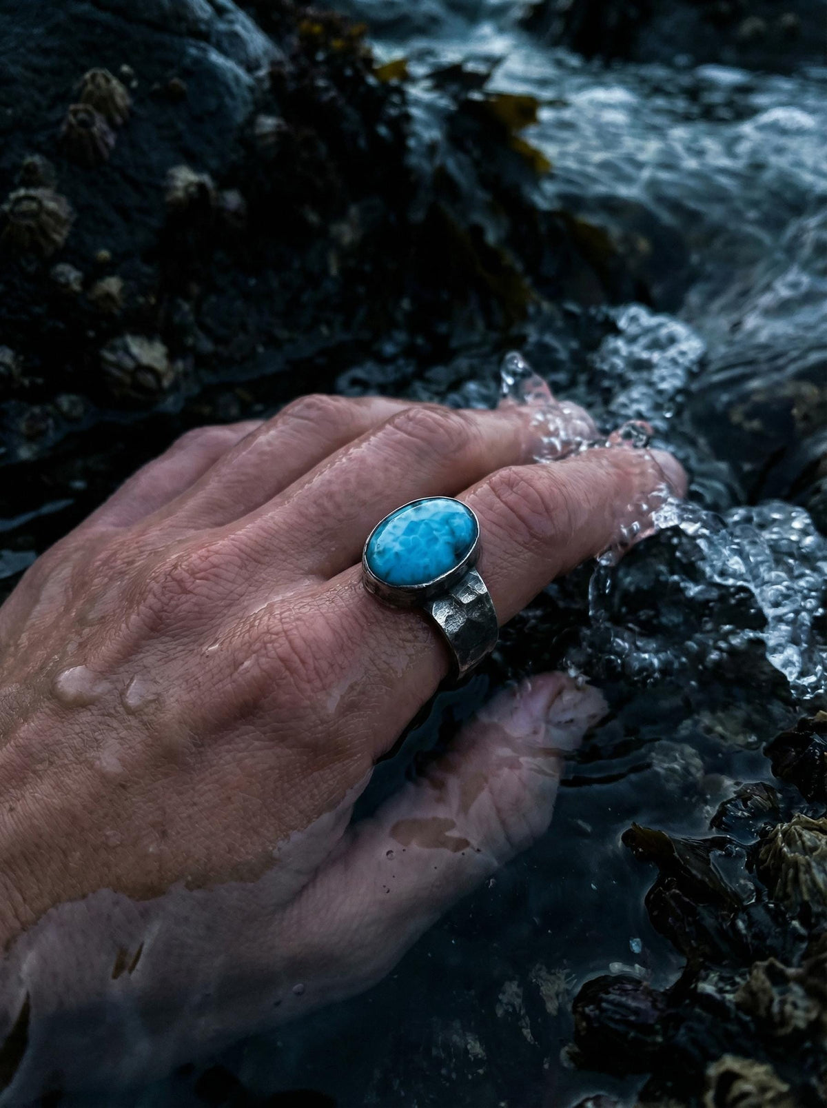 AAA Larimar sterling silver ring shown worn on hand with blue ocean stone and hammered silver band.