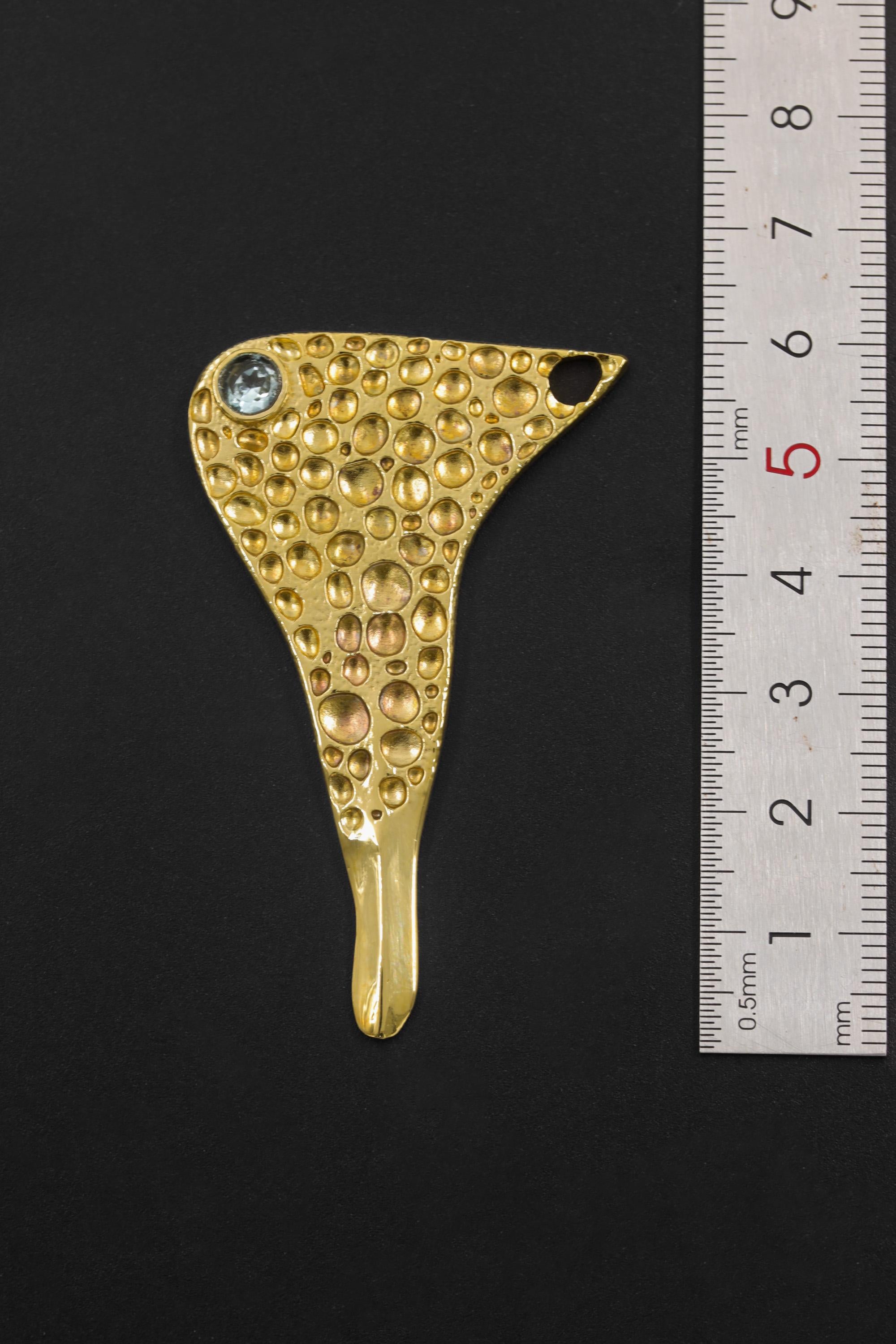 Golden Ritual Blue Topaz spoon pendant shown beside a ruler for scale with gold-plated brass and side bail.