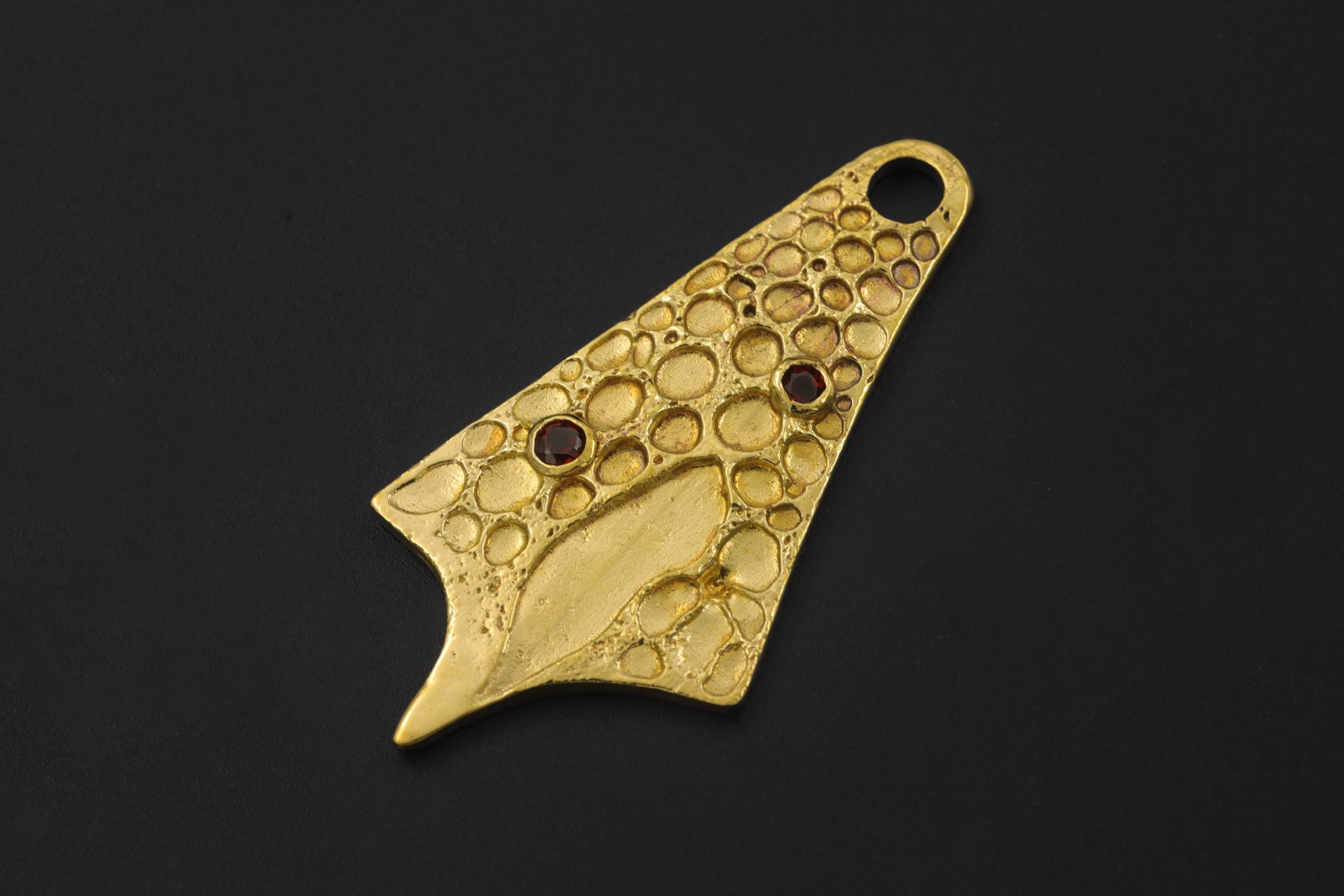 Gold-plated Double Garnet pendant displayed on black background with organic abstract form.