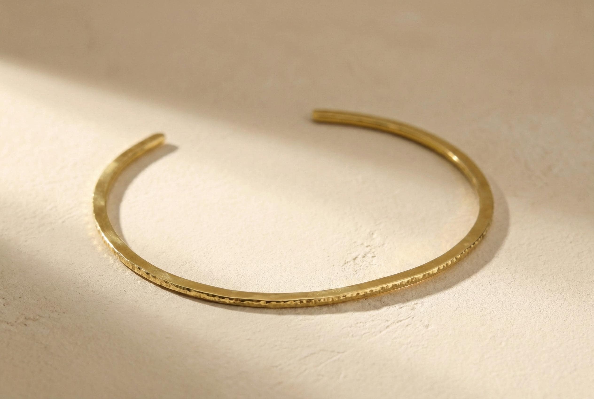 Open gold-plated brass neck cuff shown on a light background, designed for easy wear with no clasp.