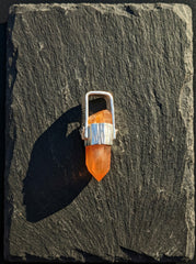 Australian Orange Lithium Lemurian Quartz pendant displayed on slate, with high-shine sterling silver and warm crystal point.