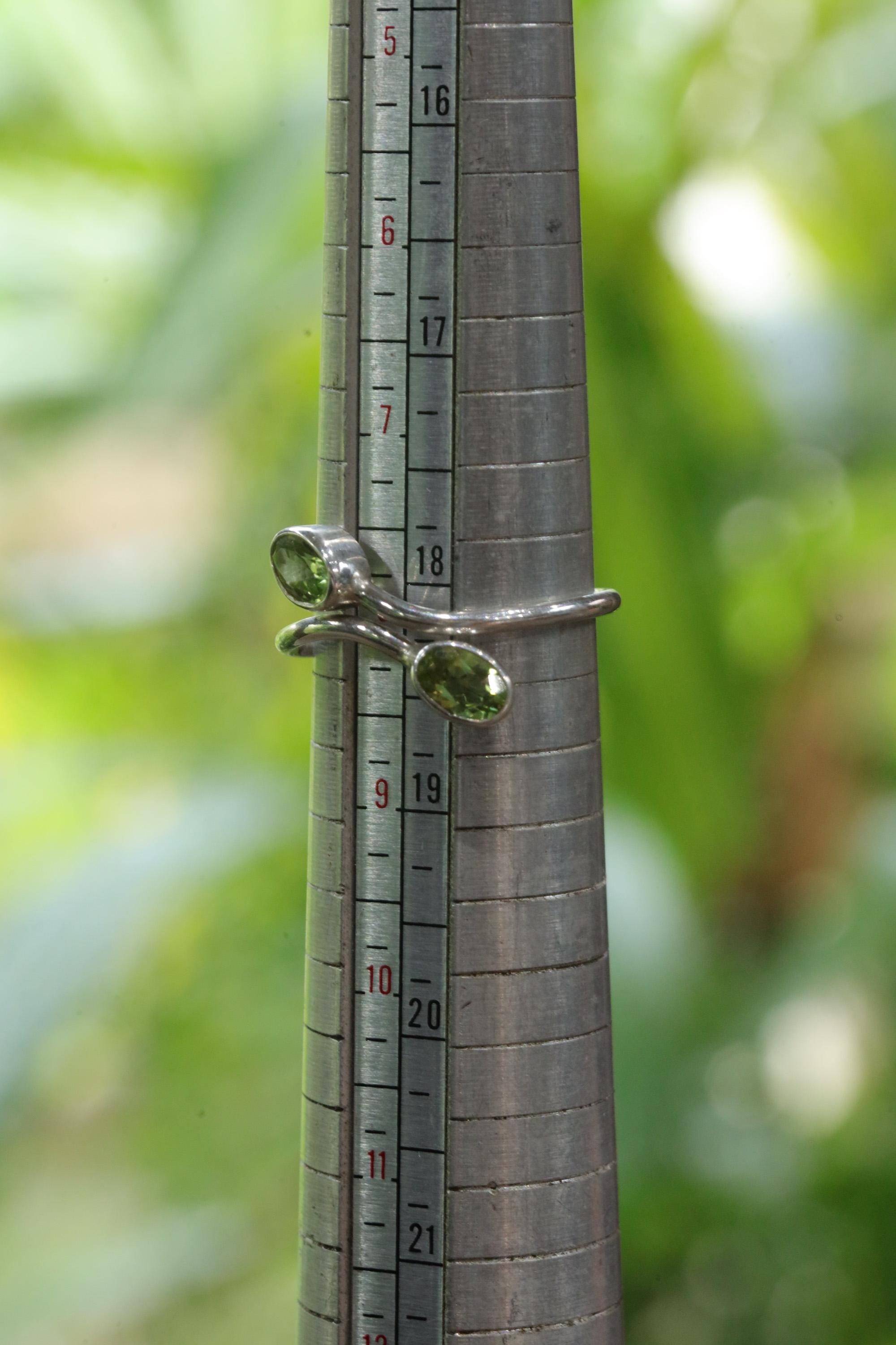 Dual Peridot sterling silver ring shown on mandrel for approximate ring size reference.
