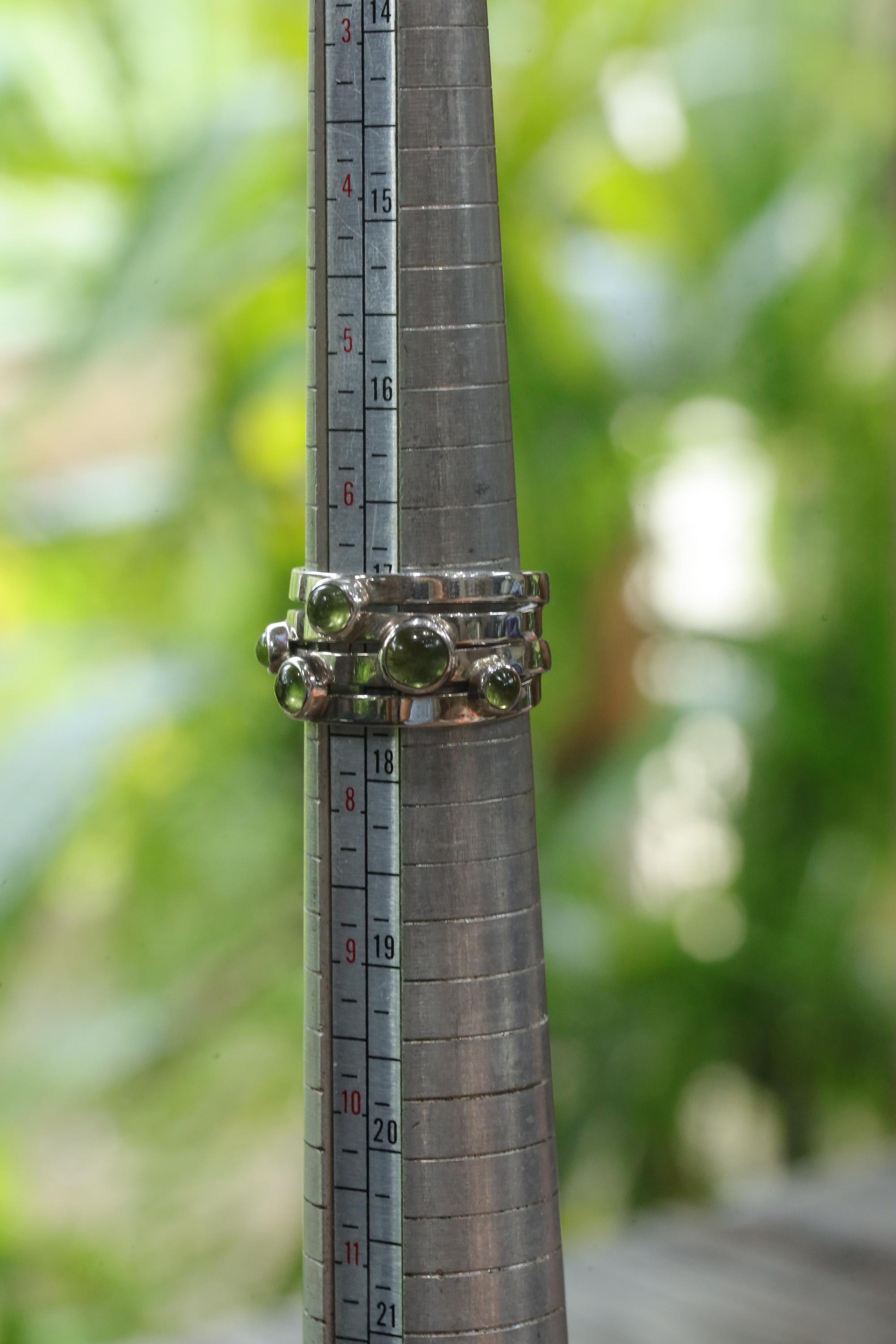 Five Stone Peridot sterling silver ring shown on mandrel for US size 7 reference.
