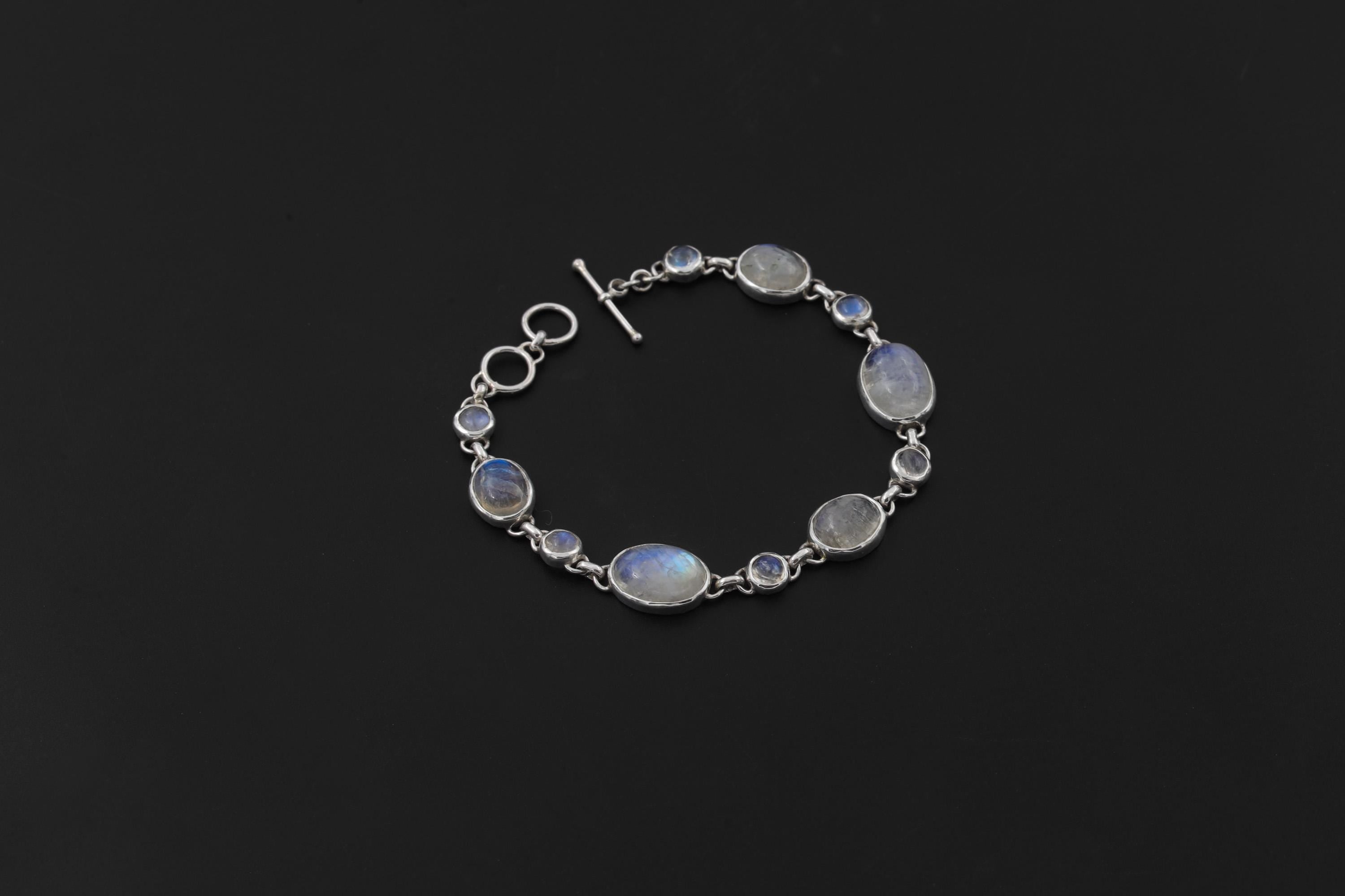 Rainbow Moonstone bracelet displayed on dark background with toggle clasp and polished sterling silver links.