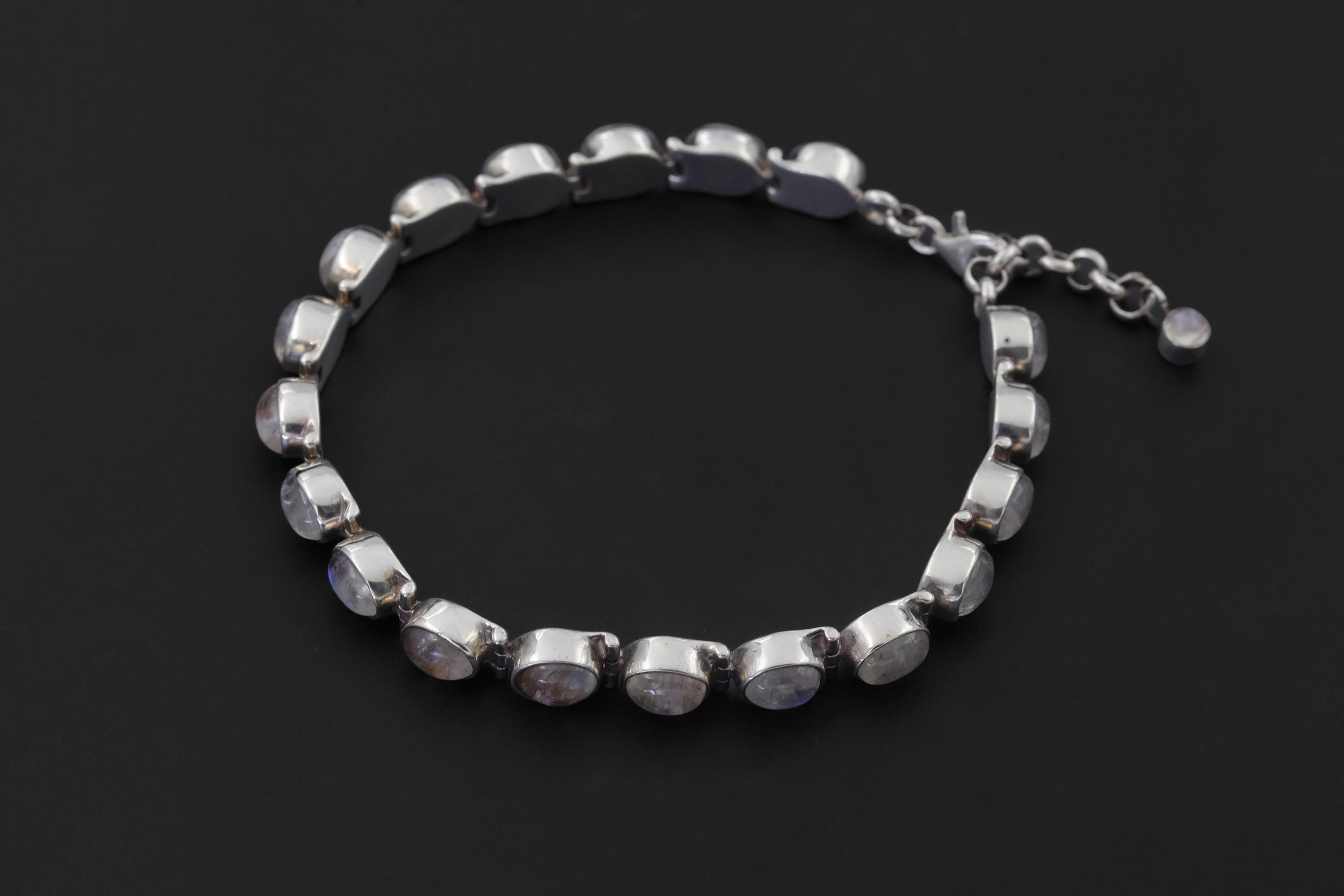 Blue Moonstone sterling silver bracelet displayed on dark background with linked oval gemstone settings.