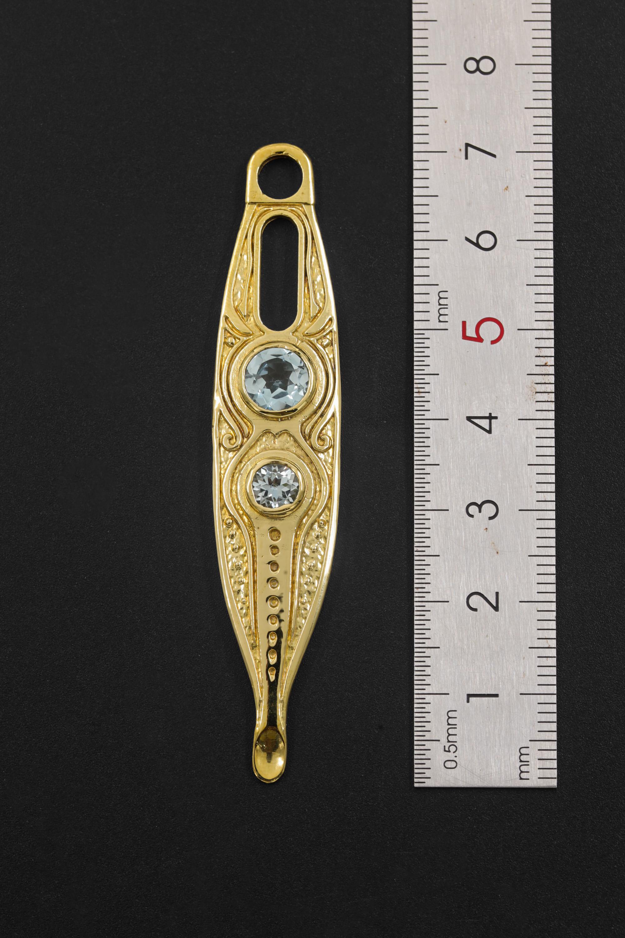 Gold Plated Blue Topaz Spoon Talisman shown beside a ruler for scale, with integrated bail and long brass spoon form.