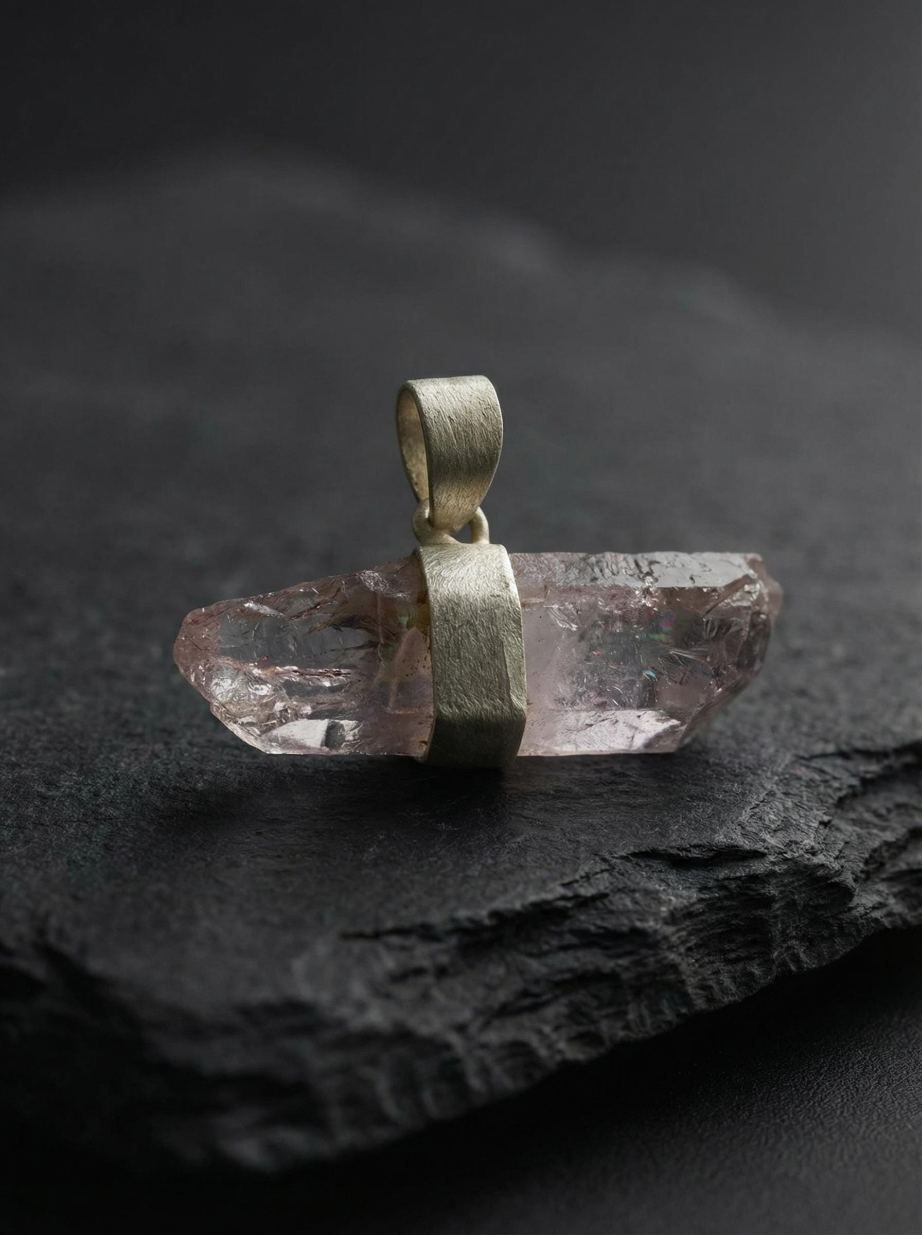 Anhydro Vera Cruz Amethyst crystal pendant displayed on dark stone with sterling silver bail.