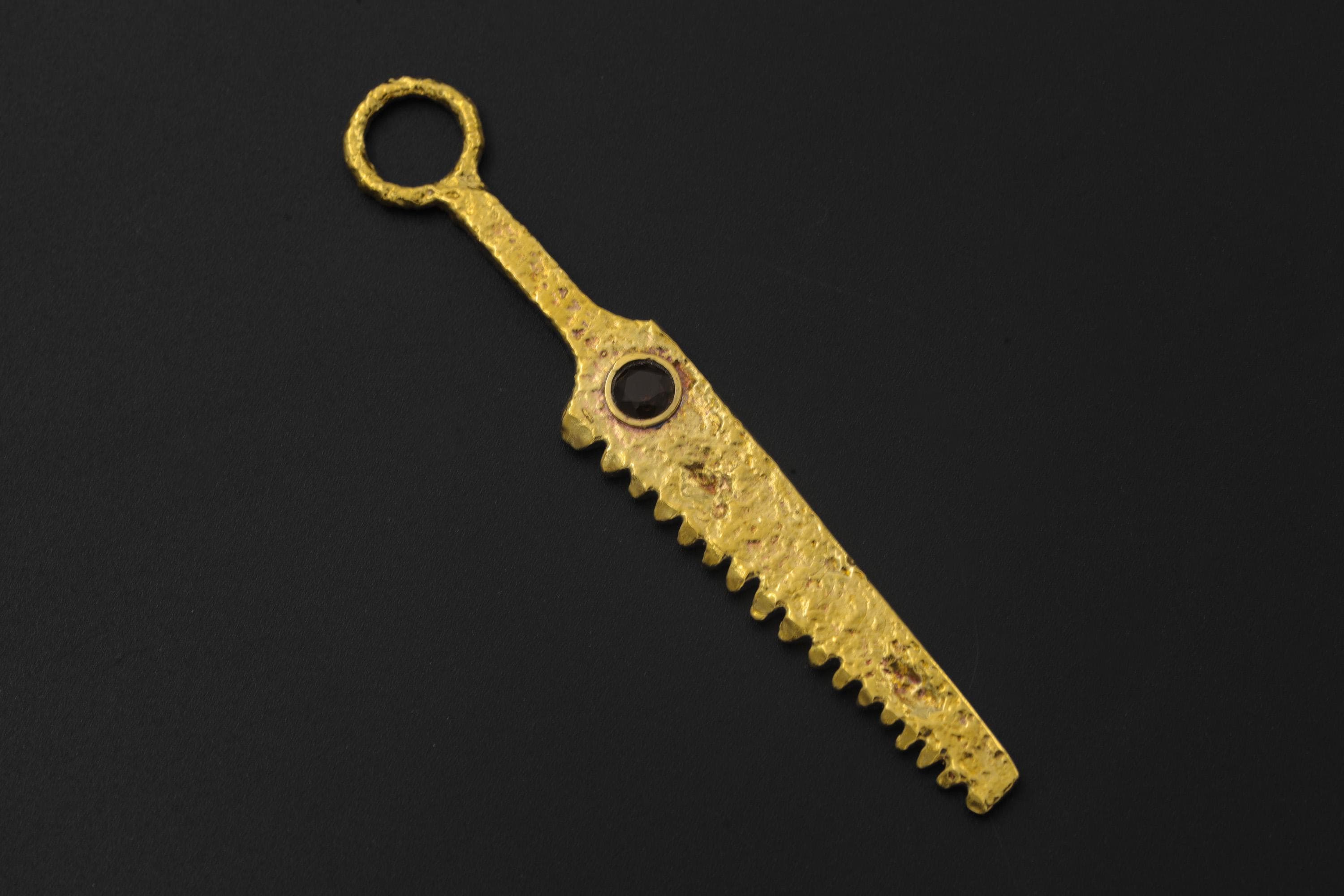 Smoky Quartz cutter spoon pendant displayed on black background with serrated gold-plated form.